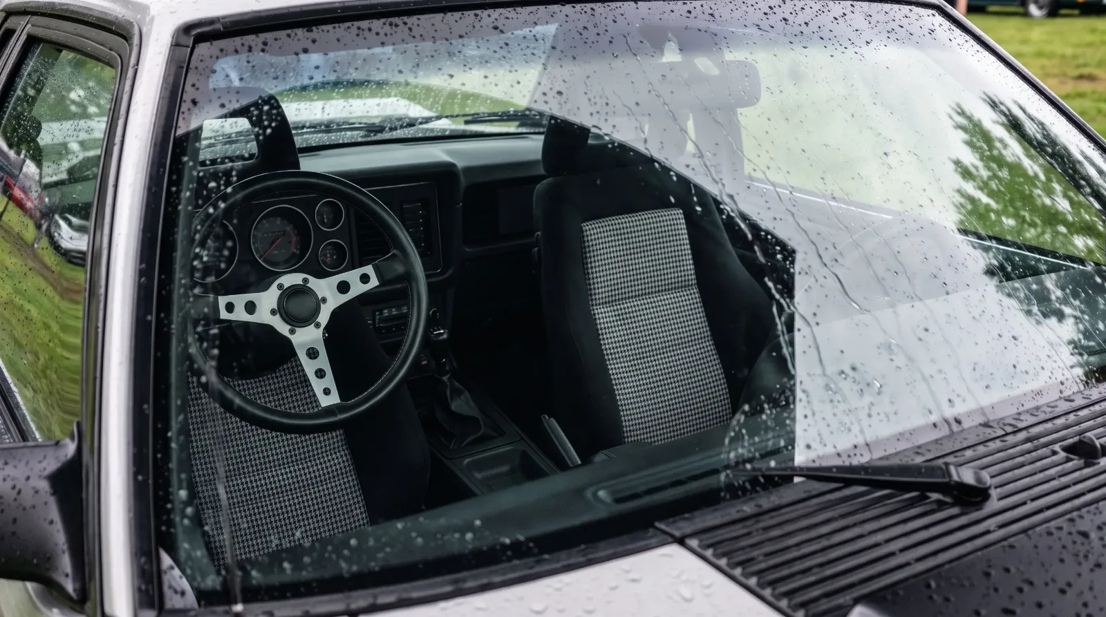 1979 Ford Mustang pace car replica Recaro seats, seen through a rain-covered windshield