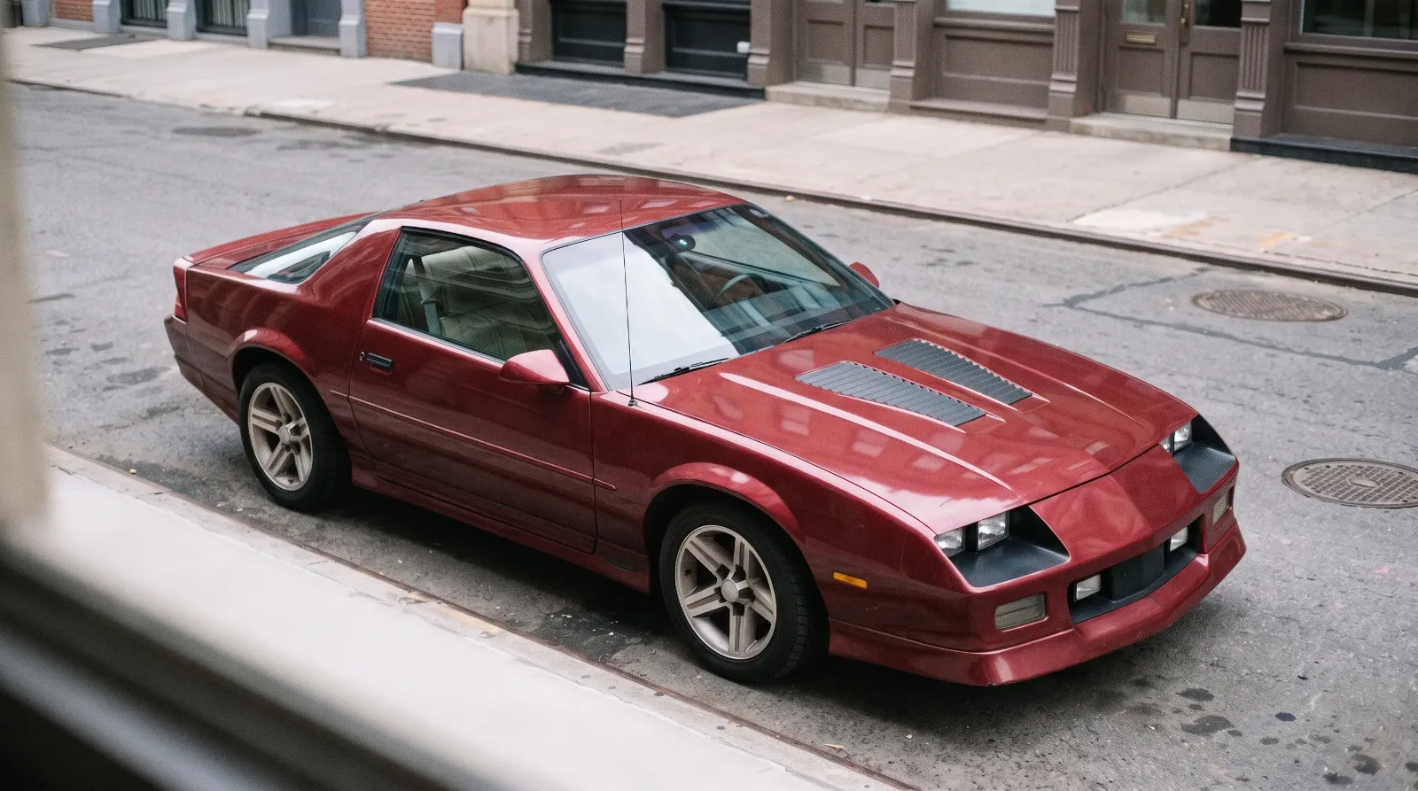 1985 Chevrolet Camaro IROC-Z from above, louvered hood and fog lamps on a city street