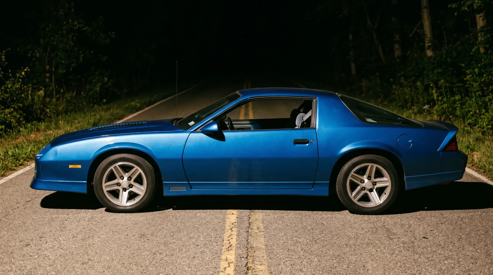 1985 Chevrolet Camaro IROC-Z, profile on a dark country road
