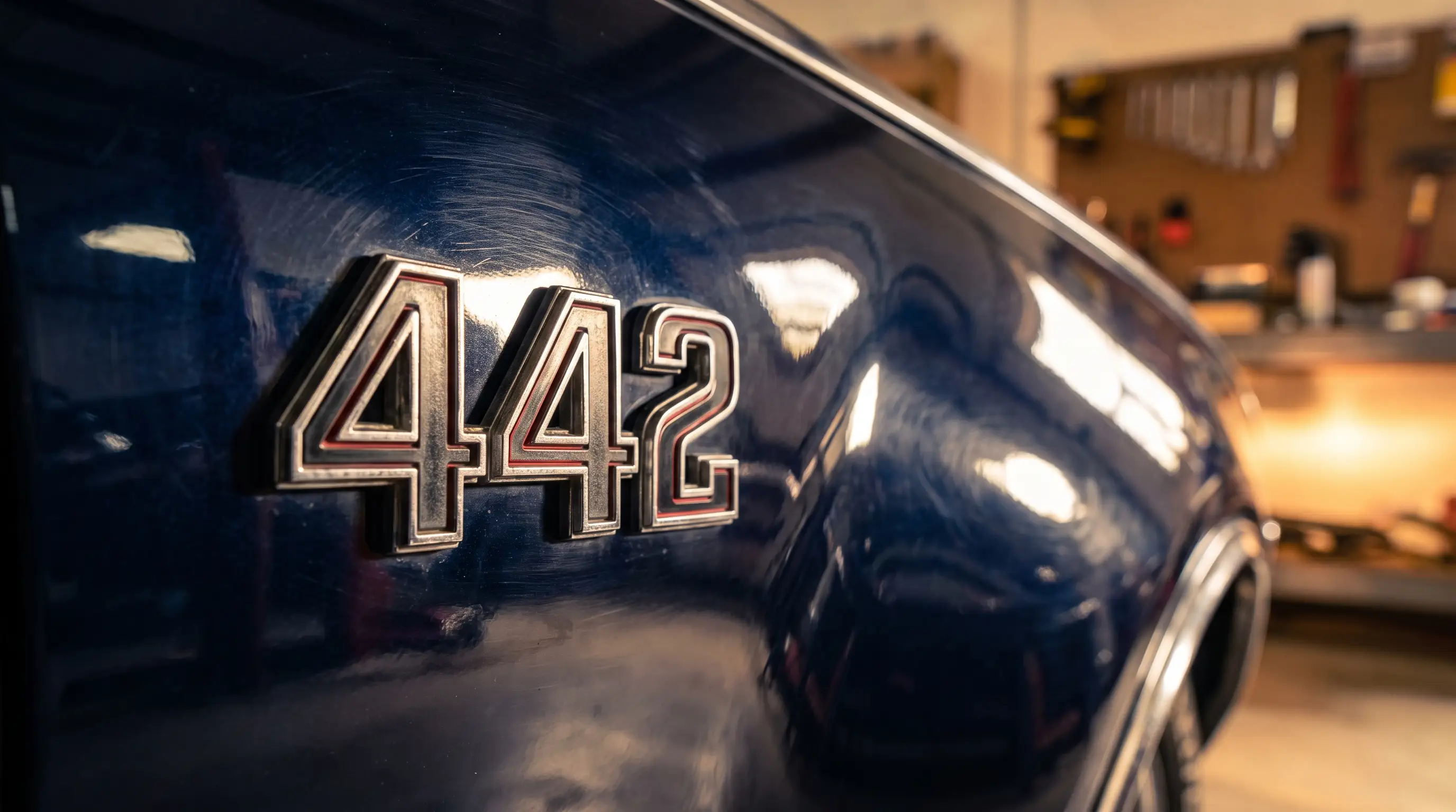 Macro shot of an Oldsmobile 442 emblem badge on a glossy fender