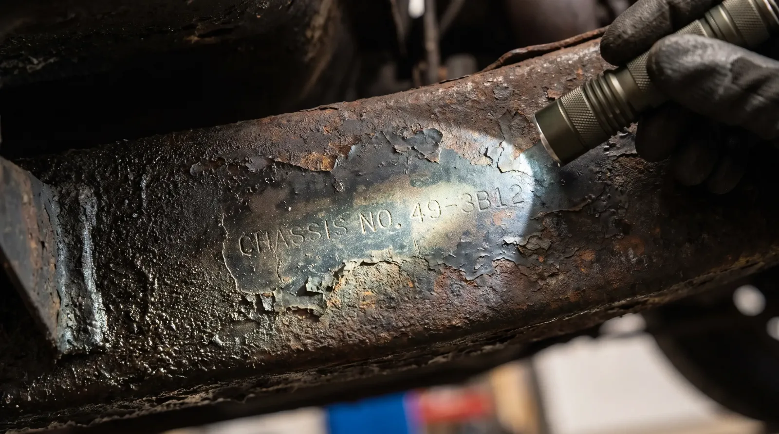 Flashlight reveals stamped chassis number under grime