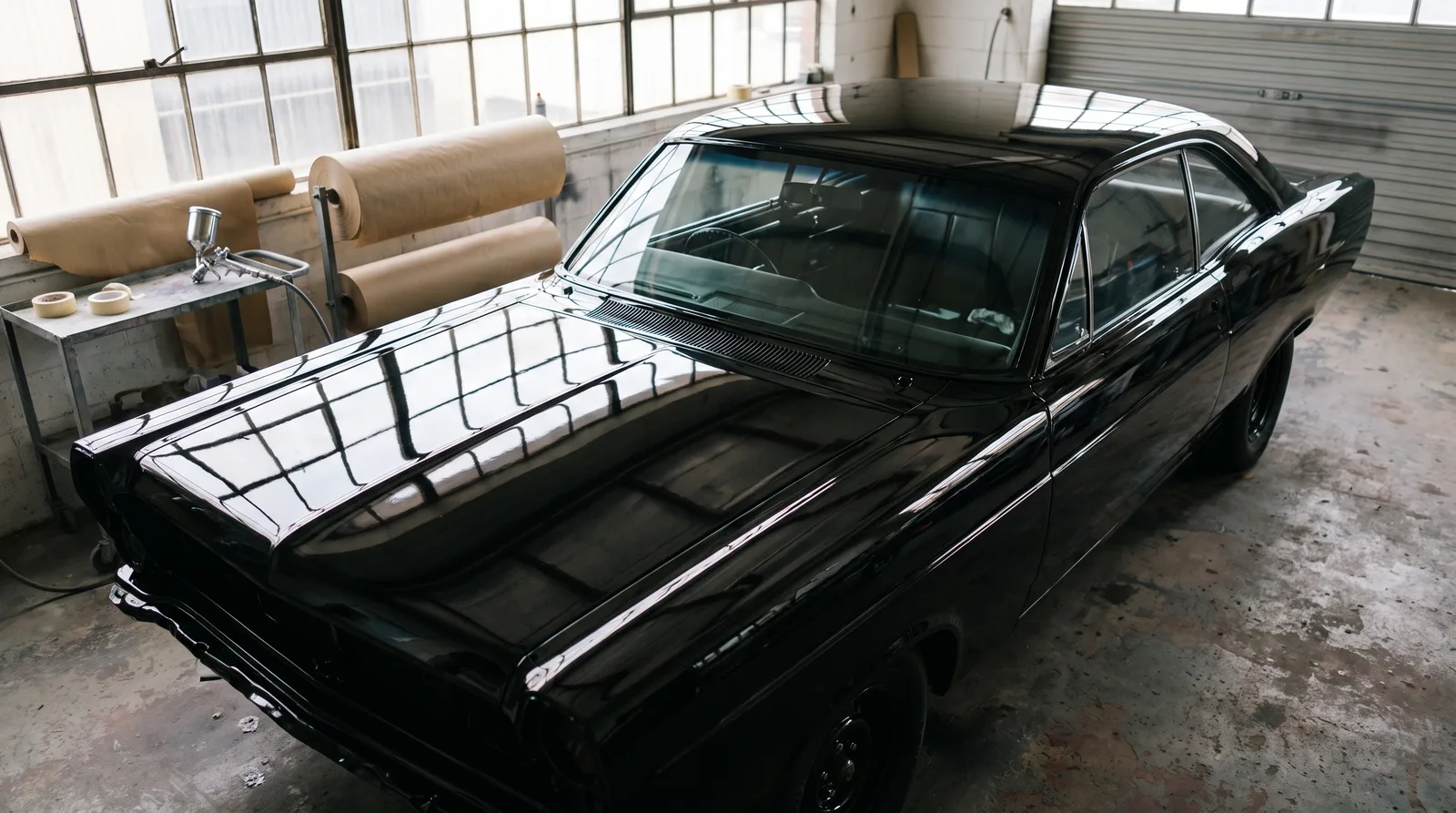 1967 Ford Fairlane hardtop â€” fresh black paint in a body shop