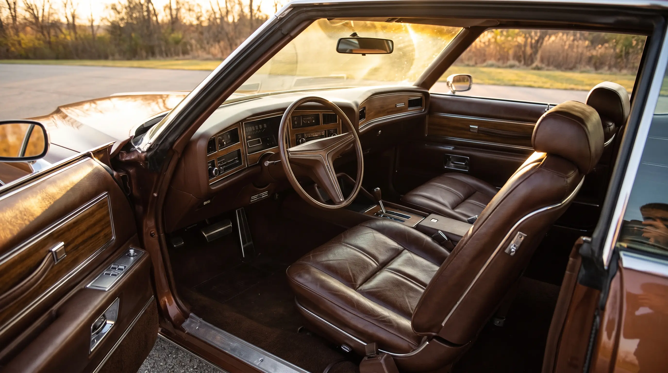 Cockpit style interior of a 1971 Buick Riviera boat tail with brown leather seats and woodgrain dash