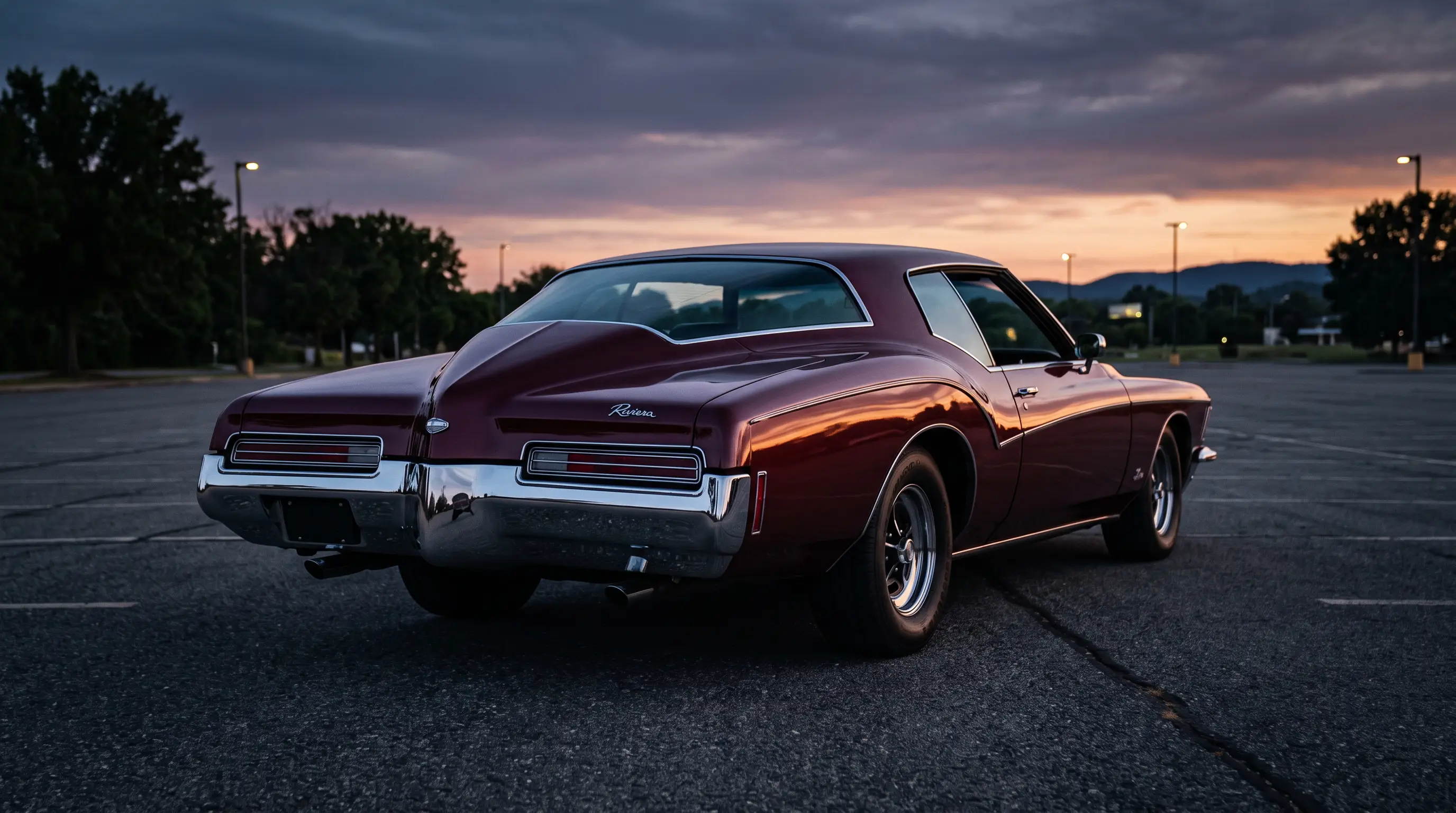 Low angle shot of a burgundy boat tail Buick Riviera at dusk