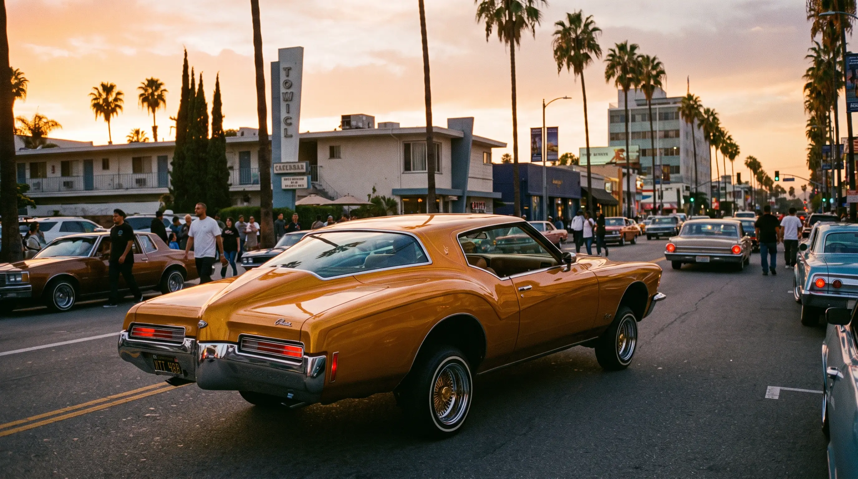 Candy gold boat tail Buick Riviera lowrider on chrome wire wheels cruising a palm lined boulevard
