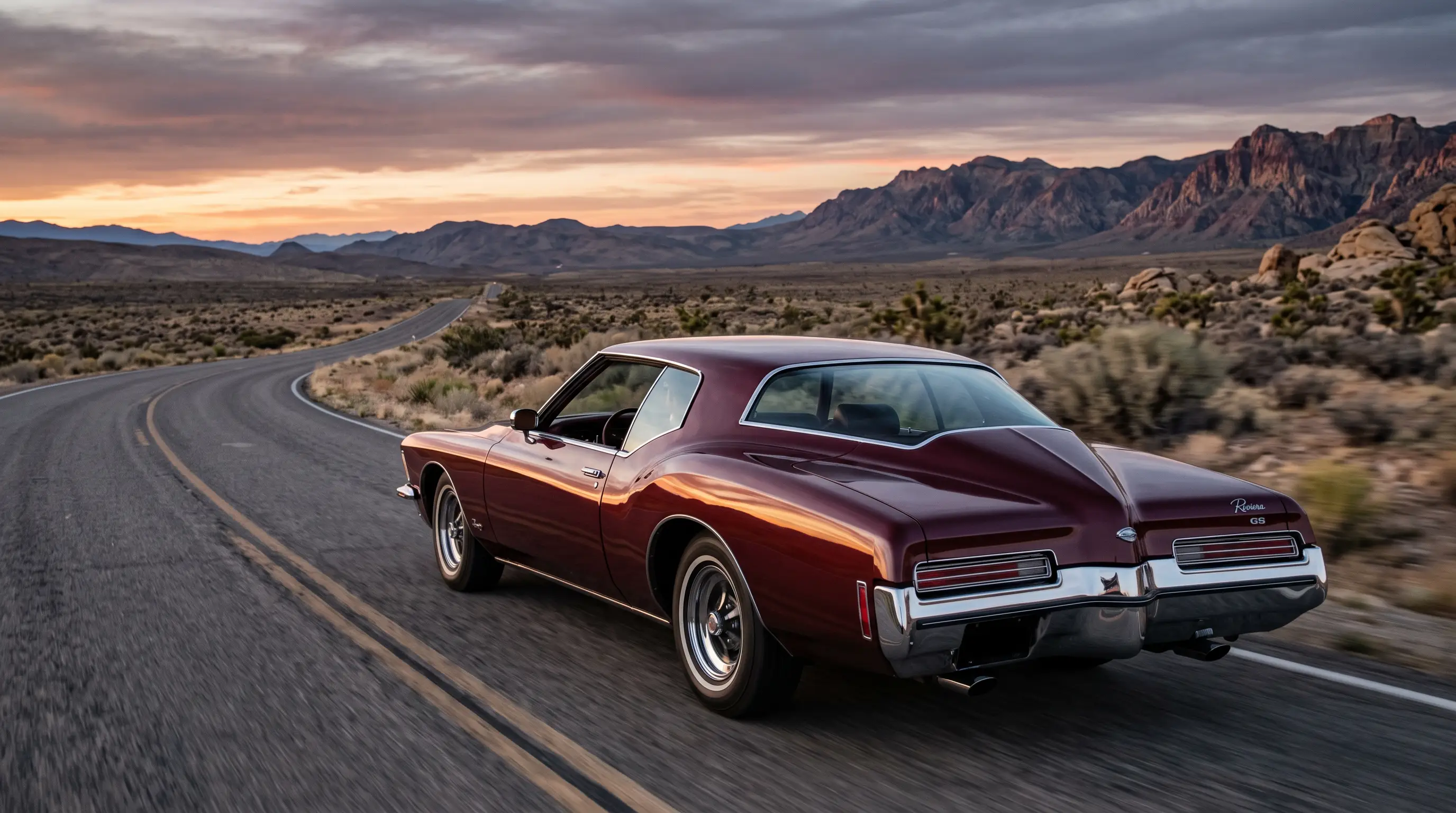 Burgundy 1971 Buick Riviera GS boat tail coupe on a desert highway at dusk