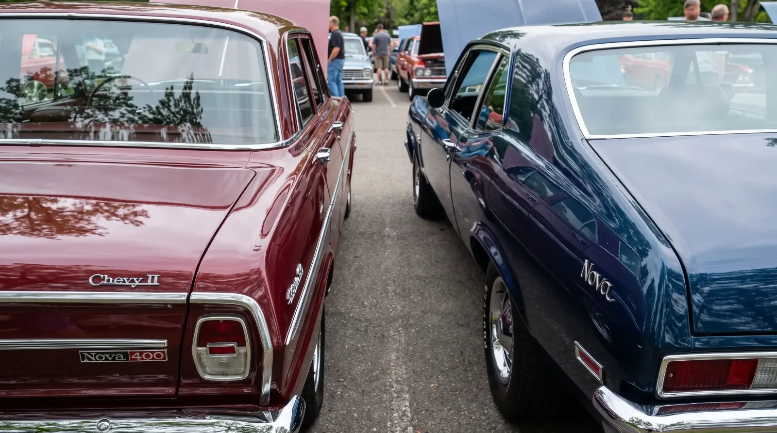 Close-up of a 1965 Chevy II Nova 400 trunk badge beside a 1969 Chevrolet Nova badge at a car show