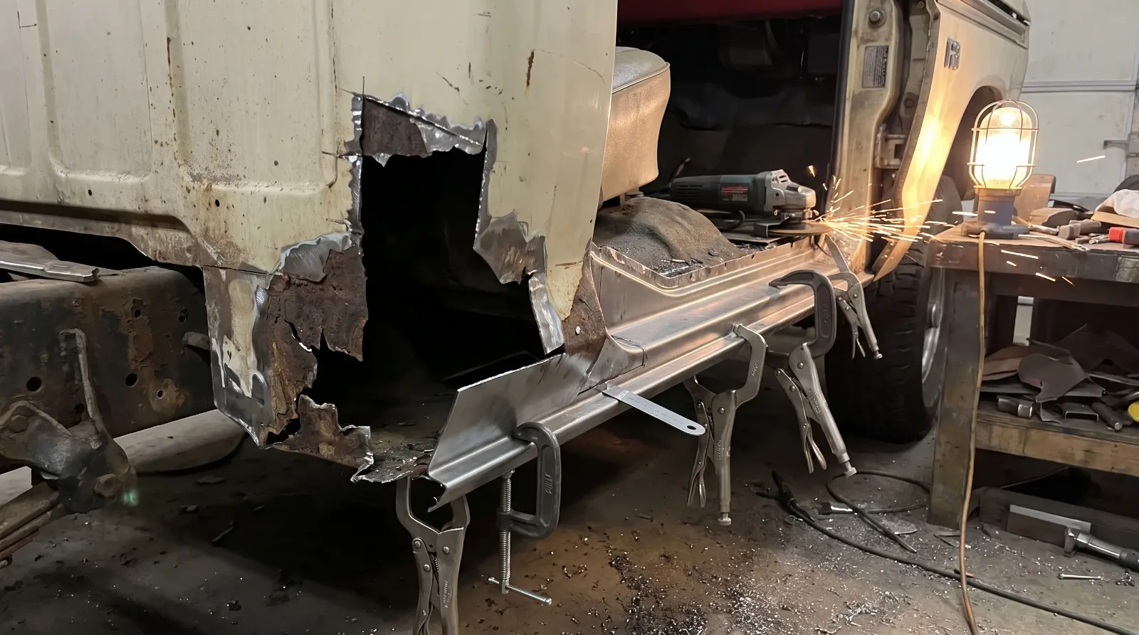 Reproduction rocker panel clamped in place for a test fit on a 1970s pickup cab before any cutting