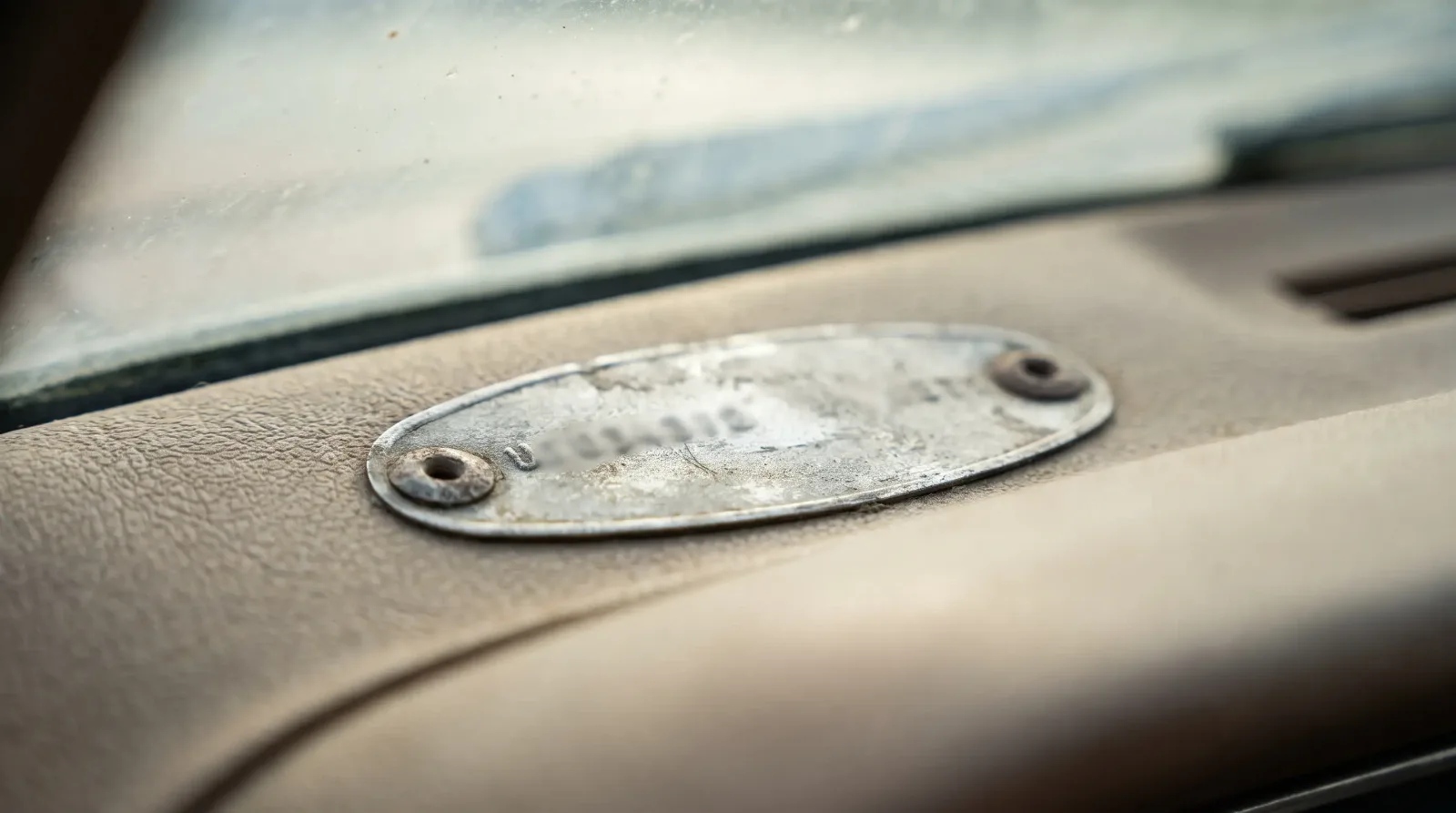 Stamped metal VIN tag on a classic Mustang dashboard