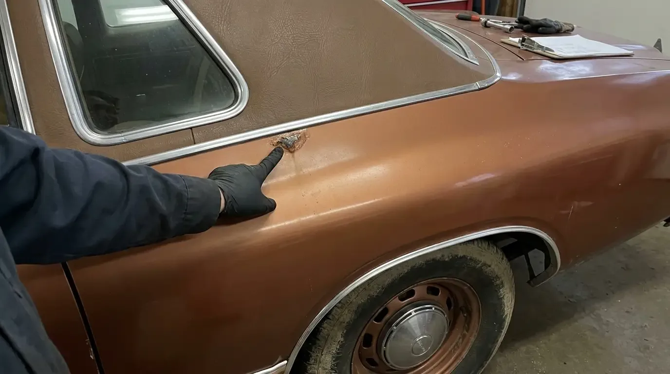 Rust inspection on the rear quarter of a 1975 Dodge Charger SE