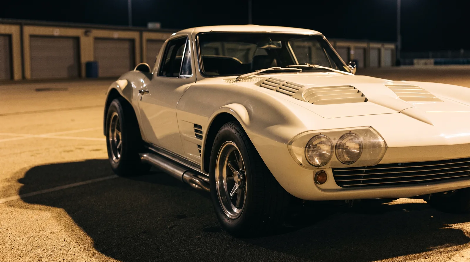 1963 Chevrolet Corvette Grand Sport, race paddock under night lamps