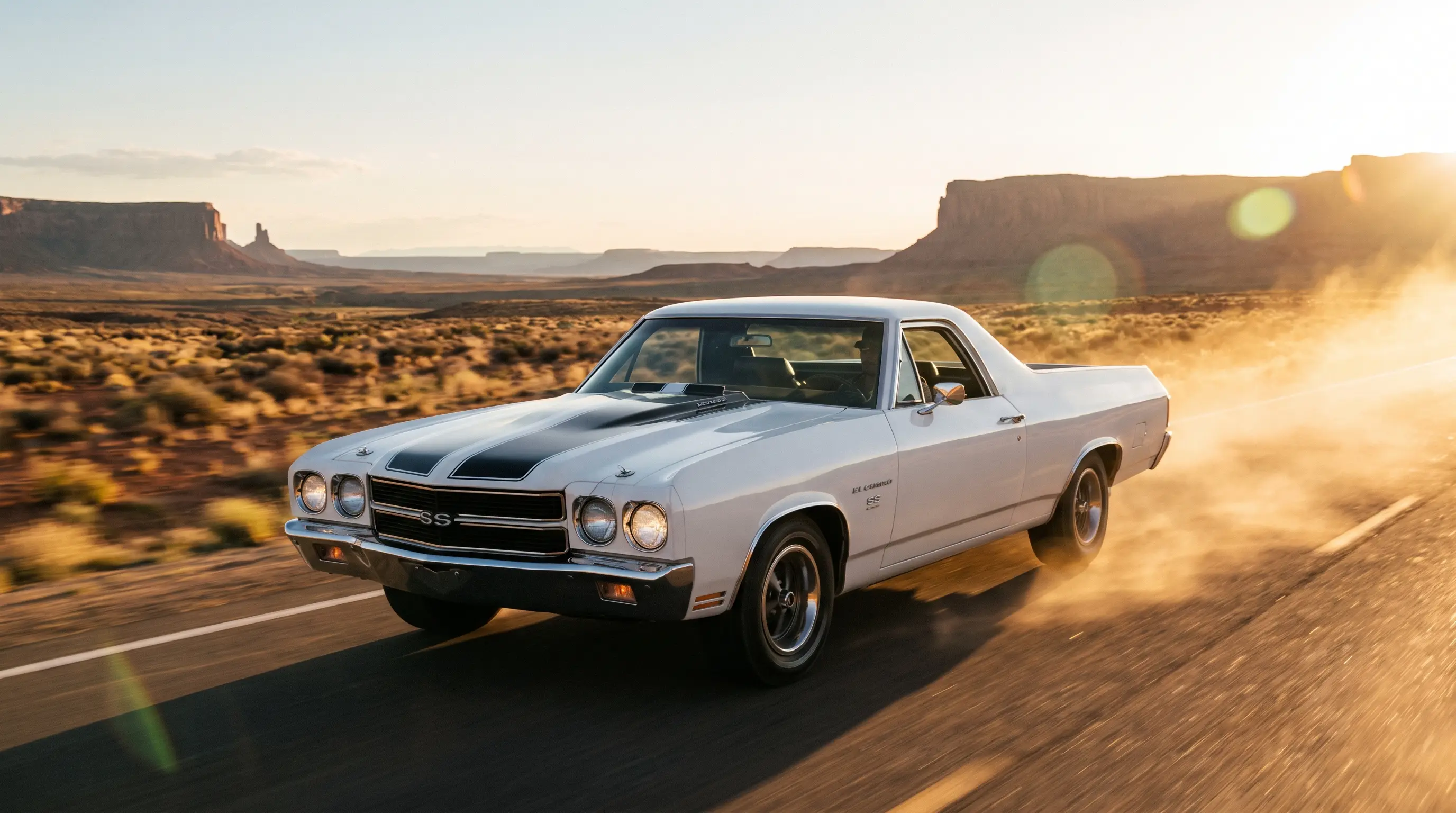 White 1970 El Camino SS 396 on a desert highway with dust at sunset