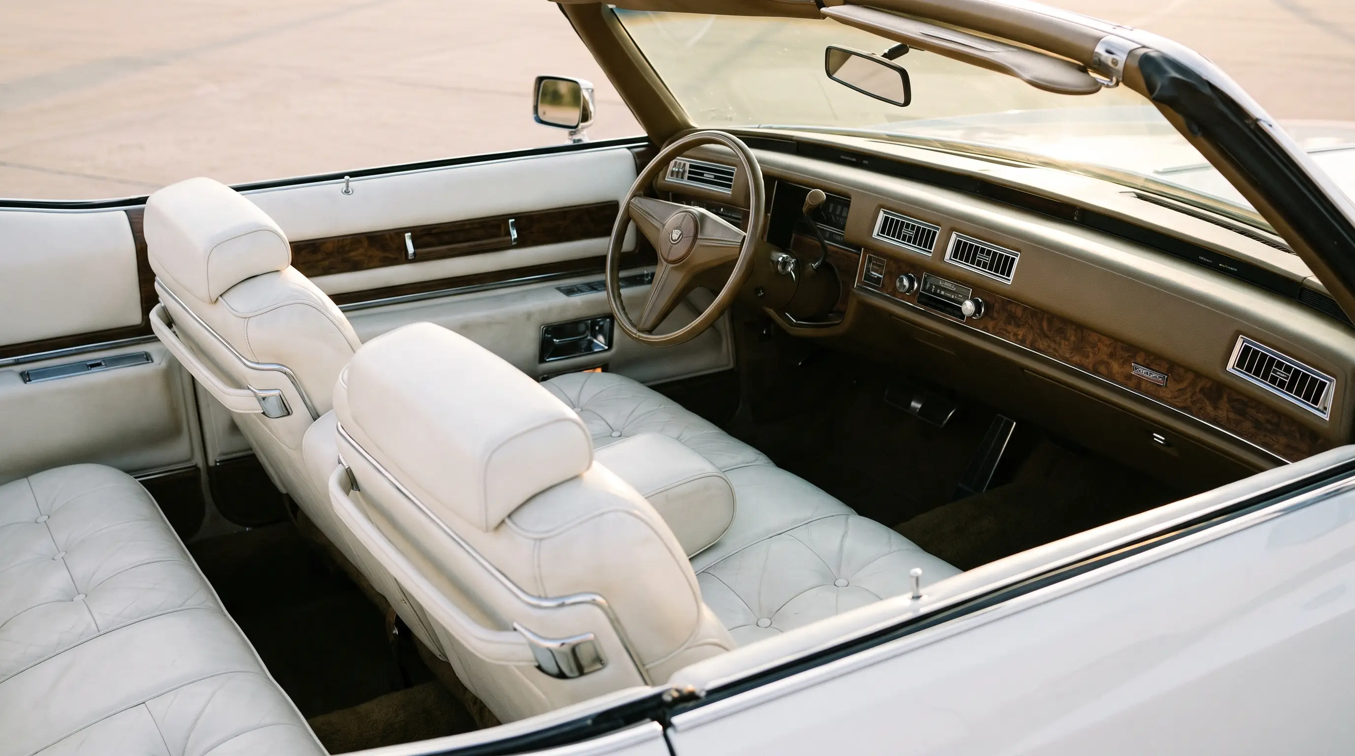 Pillowed white leather interior of a 1976 Cadillac Eldorado convertible in soft light