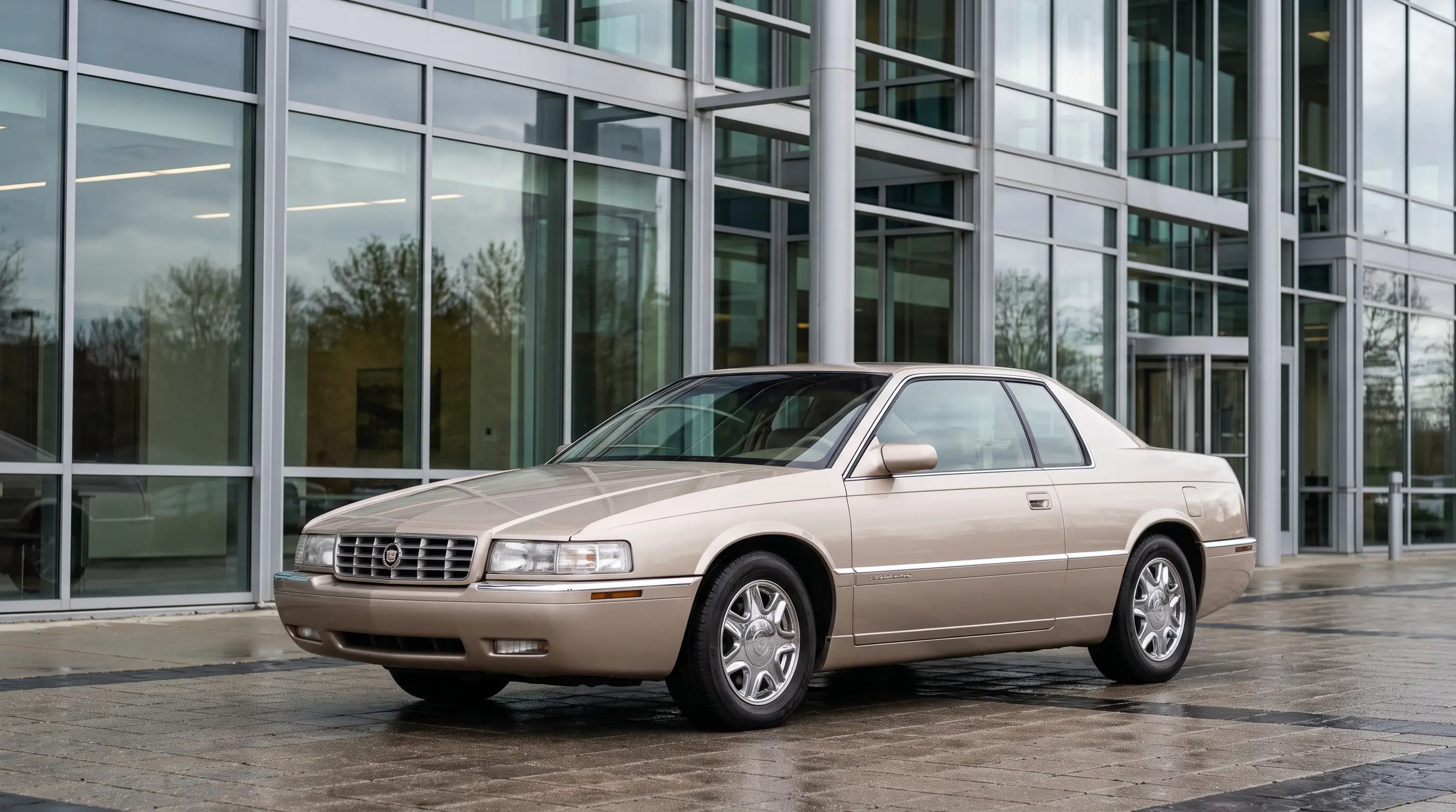 Pale gold 1990s Cadillac Eldorado Northstar coupe outside a glass showroom
