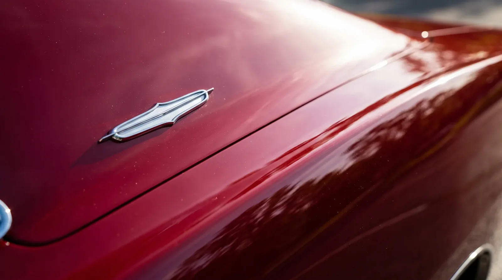 Close-up of the chrome fender emblem and body line on a red 1970 Dodge Charger R/T
