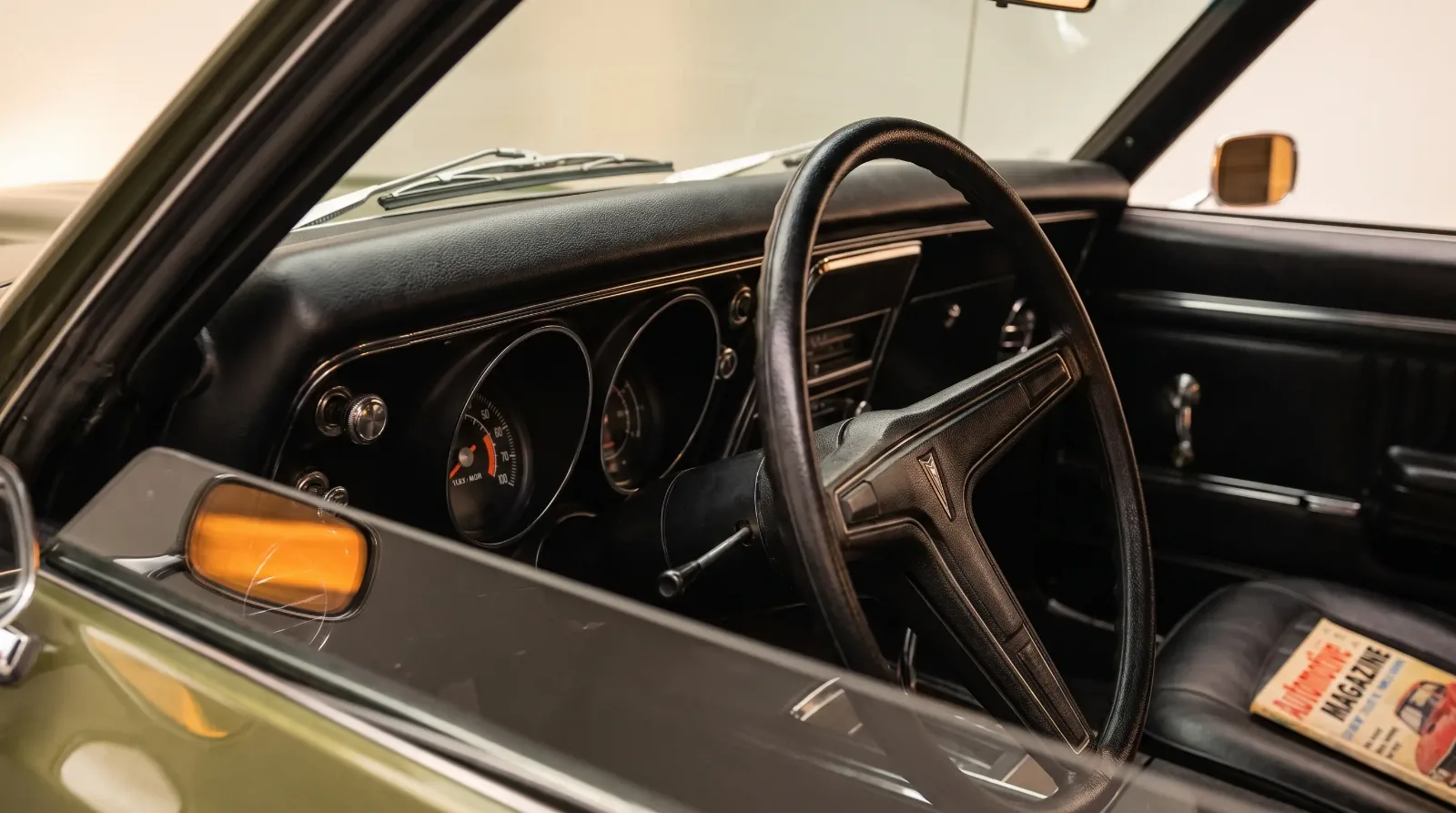 Dashboard detail of a 1968 Pontiac Firebird showing the new padded steering column and Rally gauge cluster