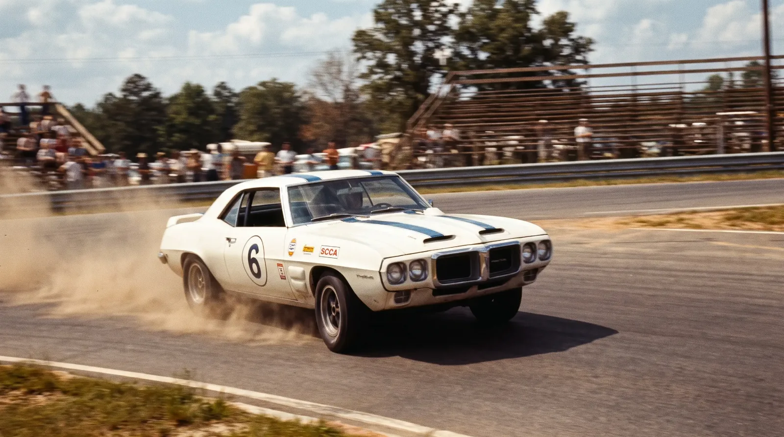 1969 Pontiac Firebird Trans Am race car cornering hard on a period SCCA Trans-Am road racing circuit