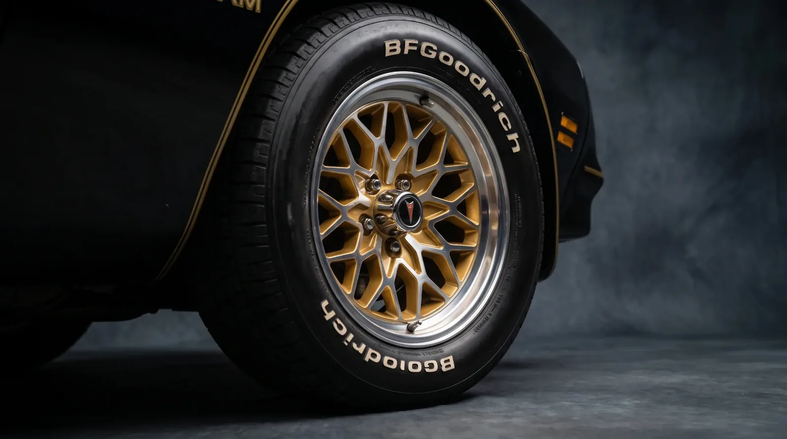 Close-up of a gold cast-aluminum snowflake wheel on a black Pontiac Trans Am