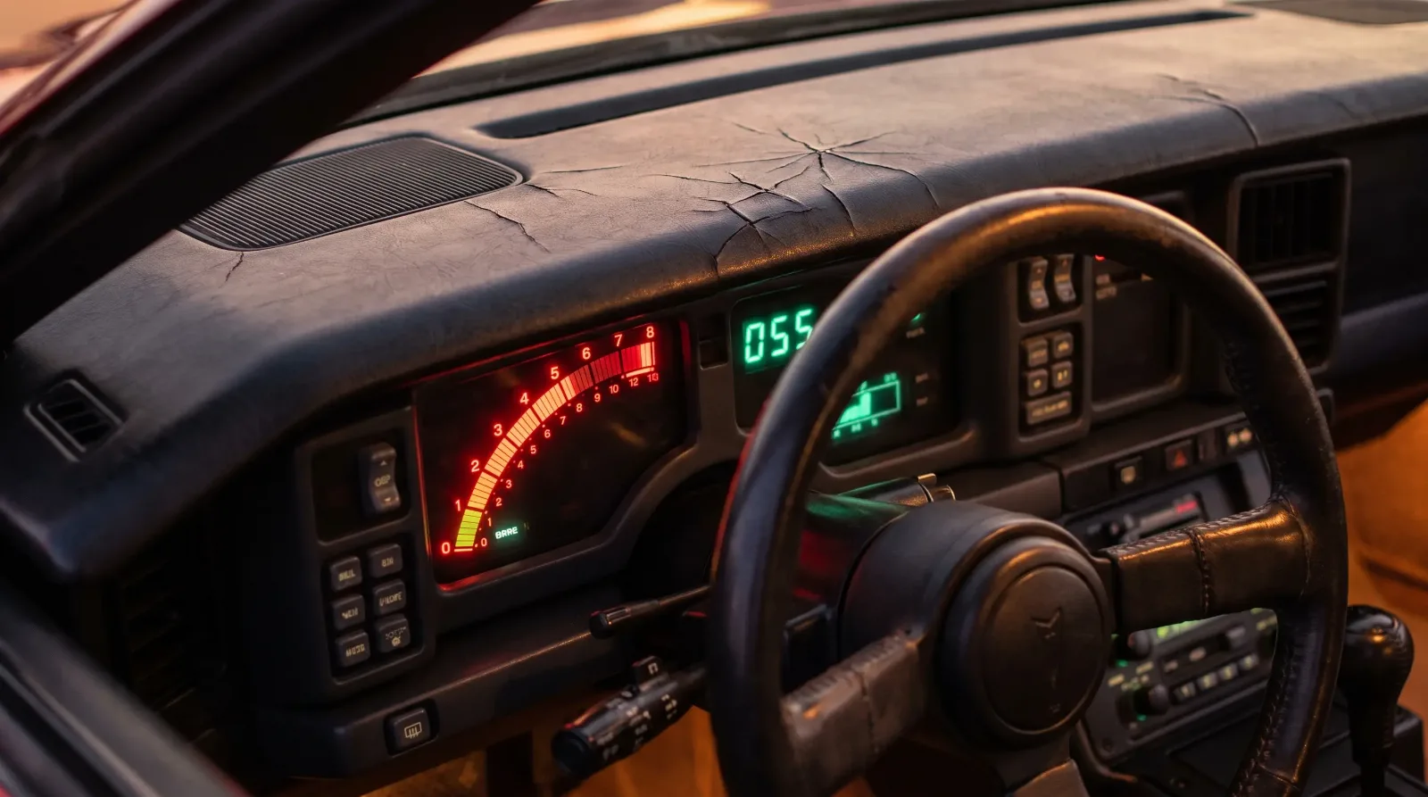 Close-up of a 1986 Pontiac Trans Am cockpit showing the glowing digital electronic instrument cluster