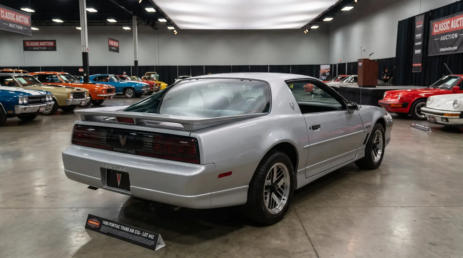 1990 Pontiac Firebird Trans Am GTA displayed on the floor of a classic car auction hall