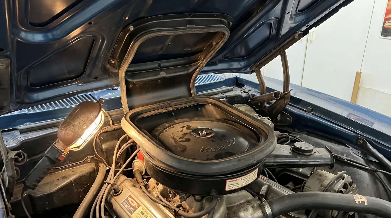 Close-up of a 1967 Pontiac Firebird 400 Ram Air hood scoop duct and air cleaner seal under a raised hood