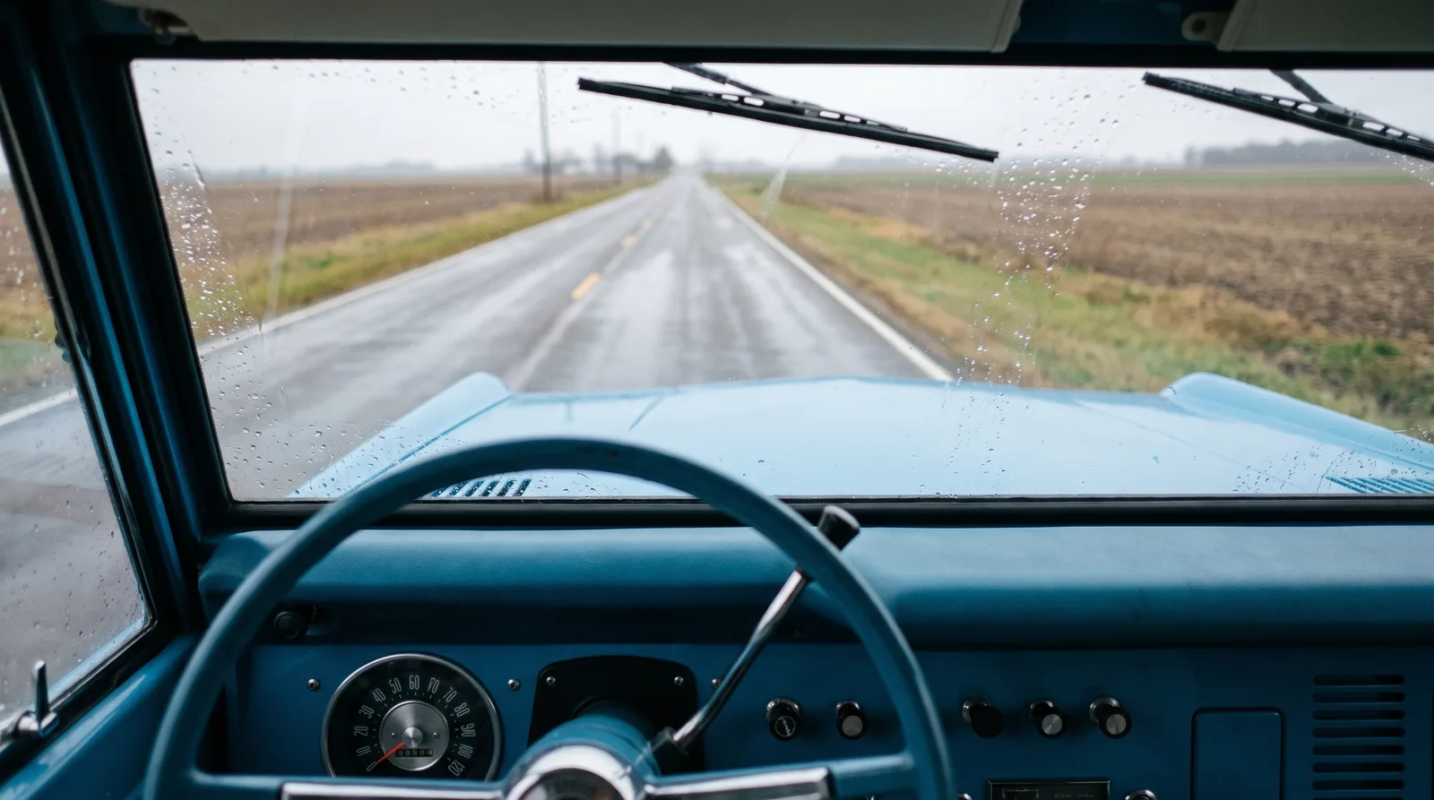 1966 Ford Bronco, rainy country road through the windshield
