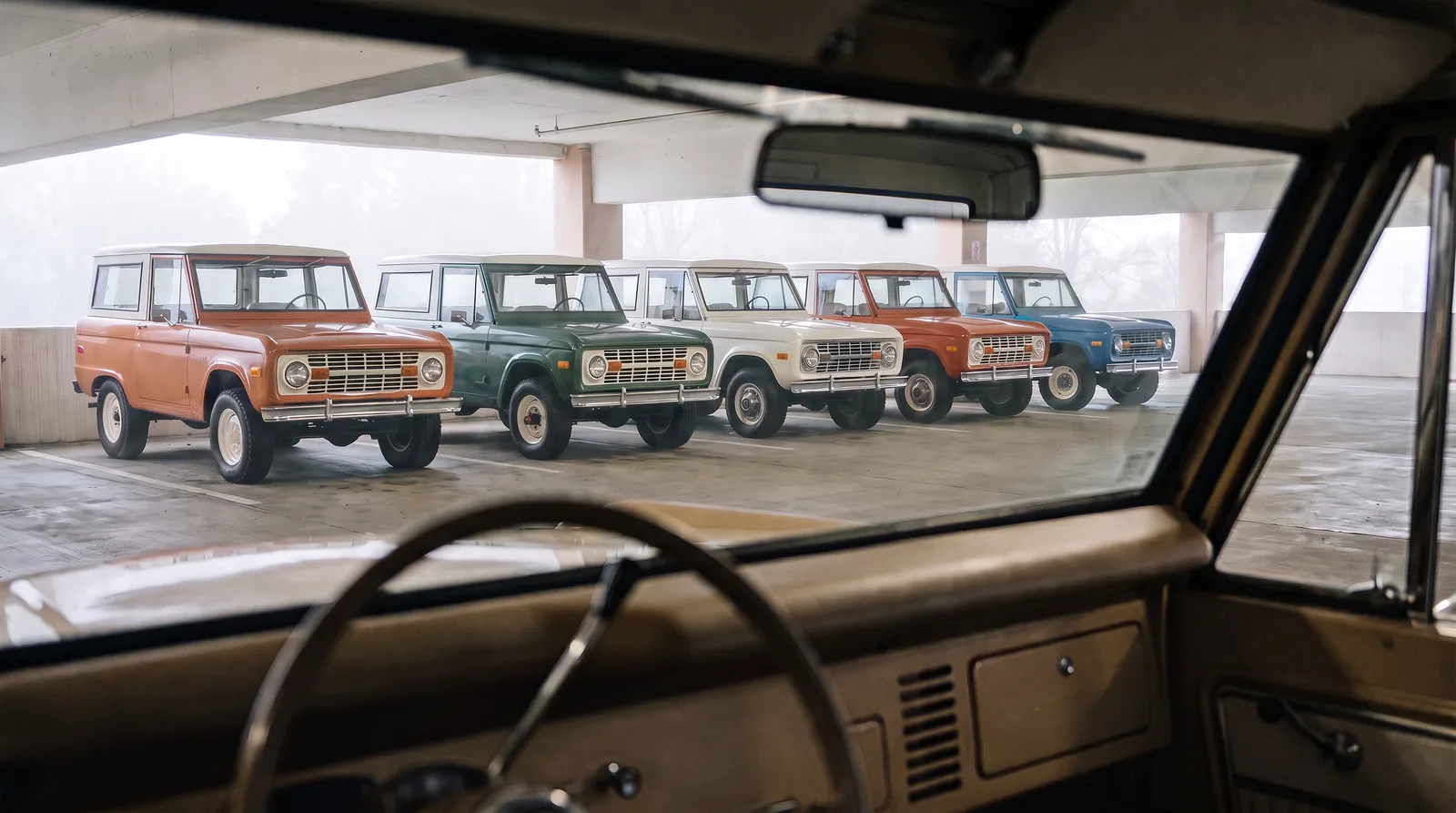 1973 Ford Bronco, row of Broncos seen through a windshield