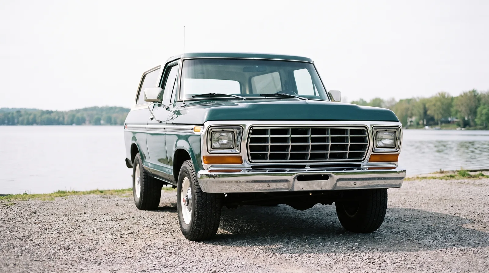 1979 Ford Bronco — parked on a lakeside gravel lot