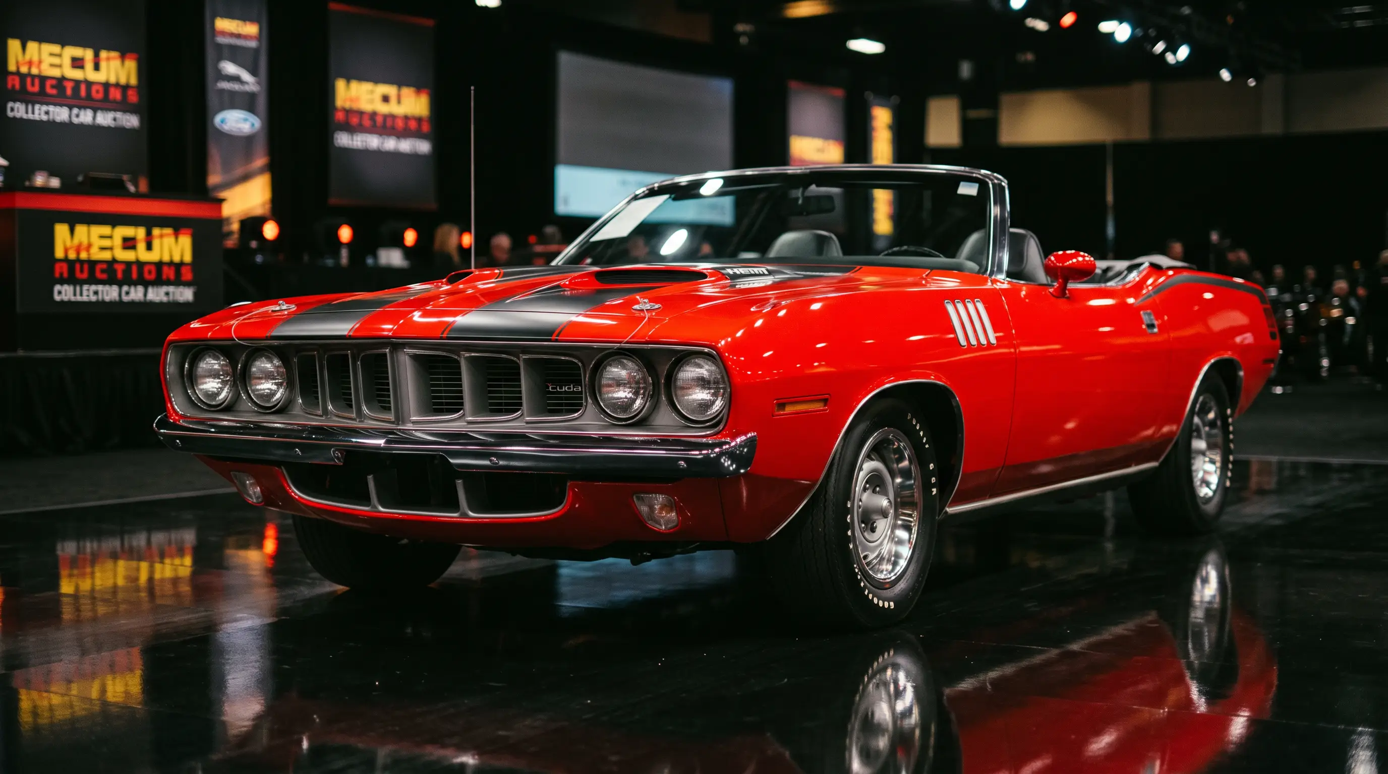 Red 1971 Hemi Cuda convertible with black stripes under dramatic auction stage lights