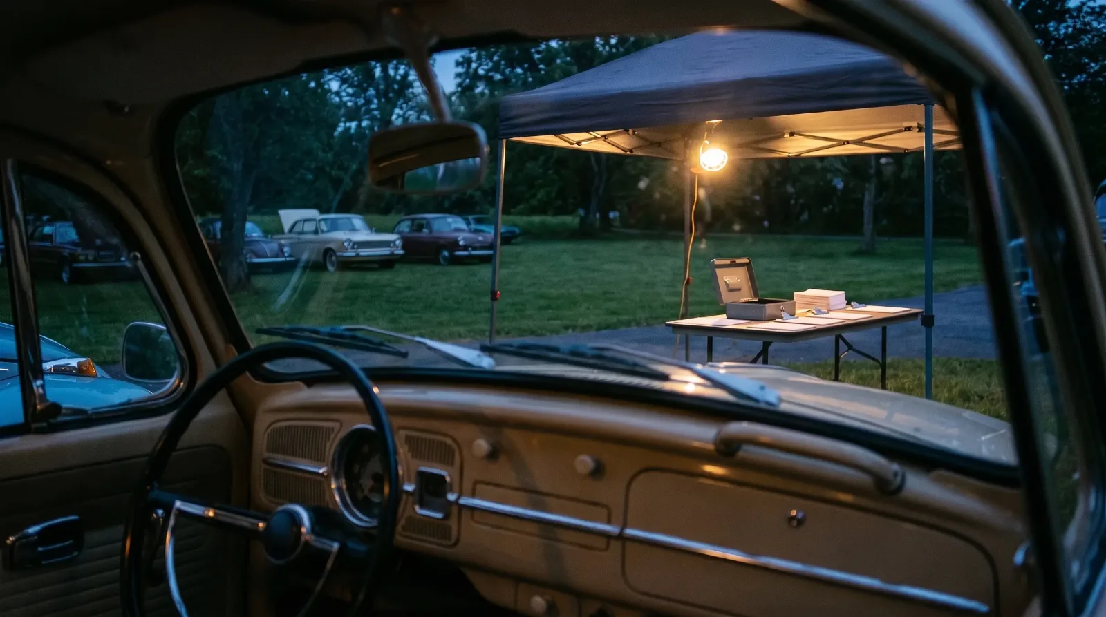 Show field registration table at dusk with a 1969 Volkswagen Beetle