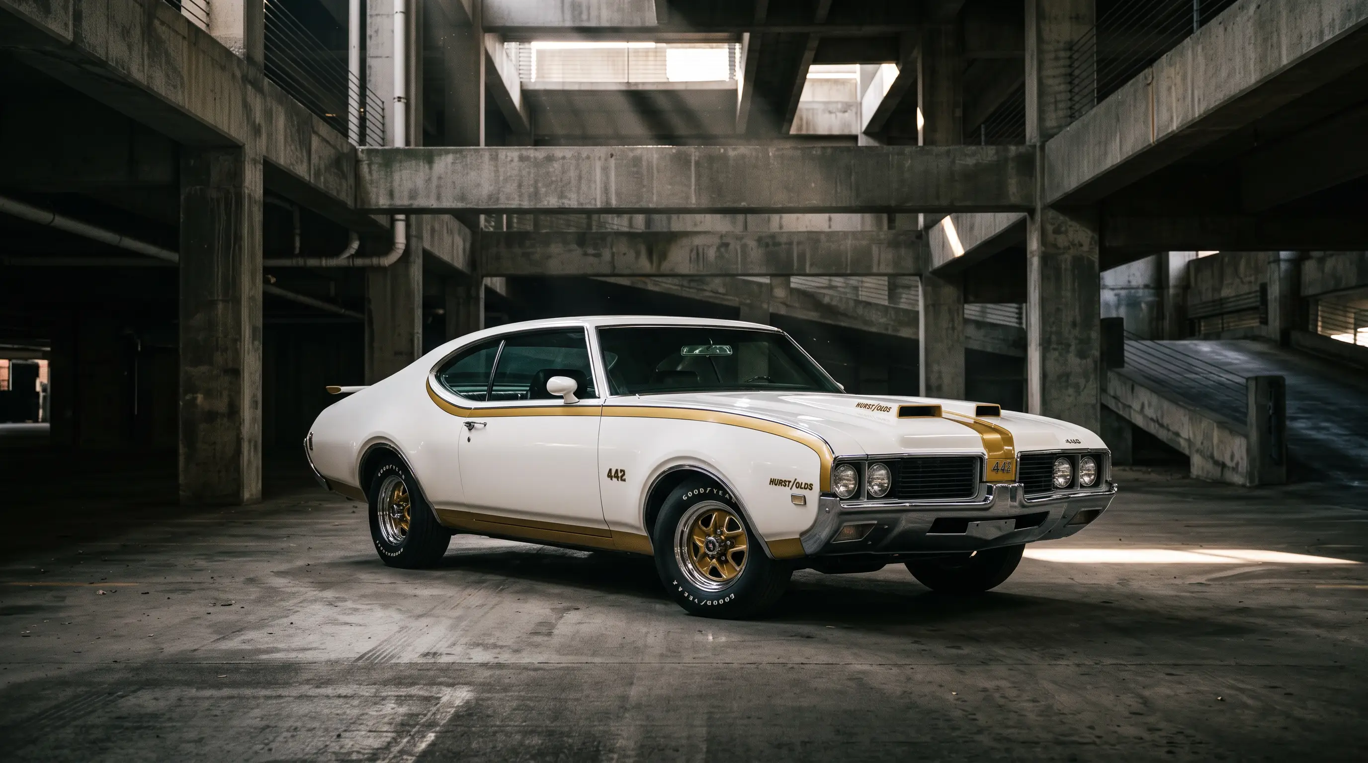 White and gold 1969 Hurst Olds 442 in a dramatic concrete parking structure with light beams