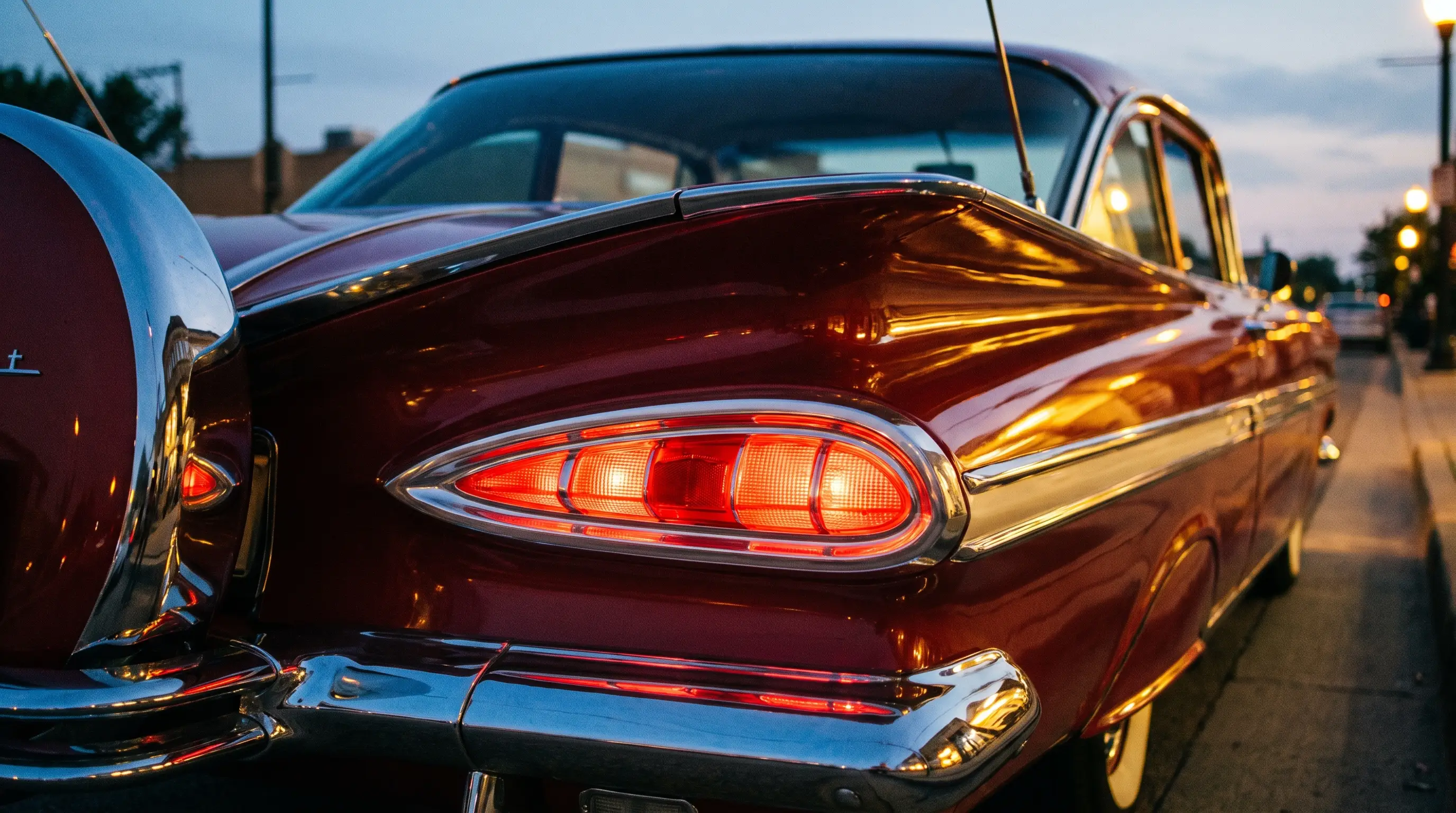 Close-up of 1959 Chevrolet Impala cat-eye taillights glowing at dusk