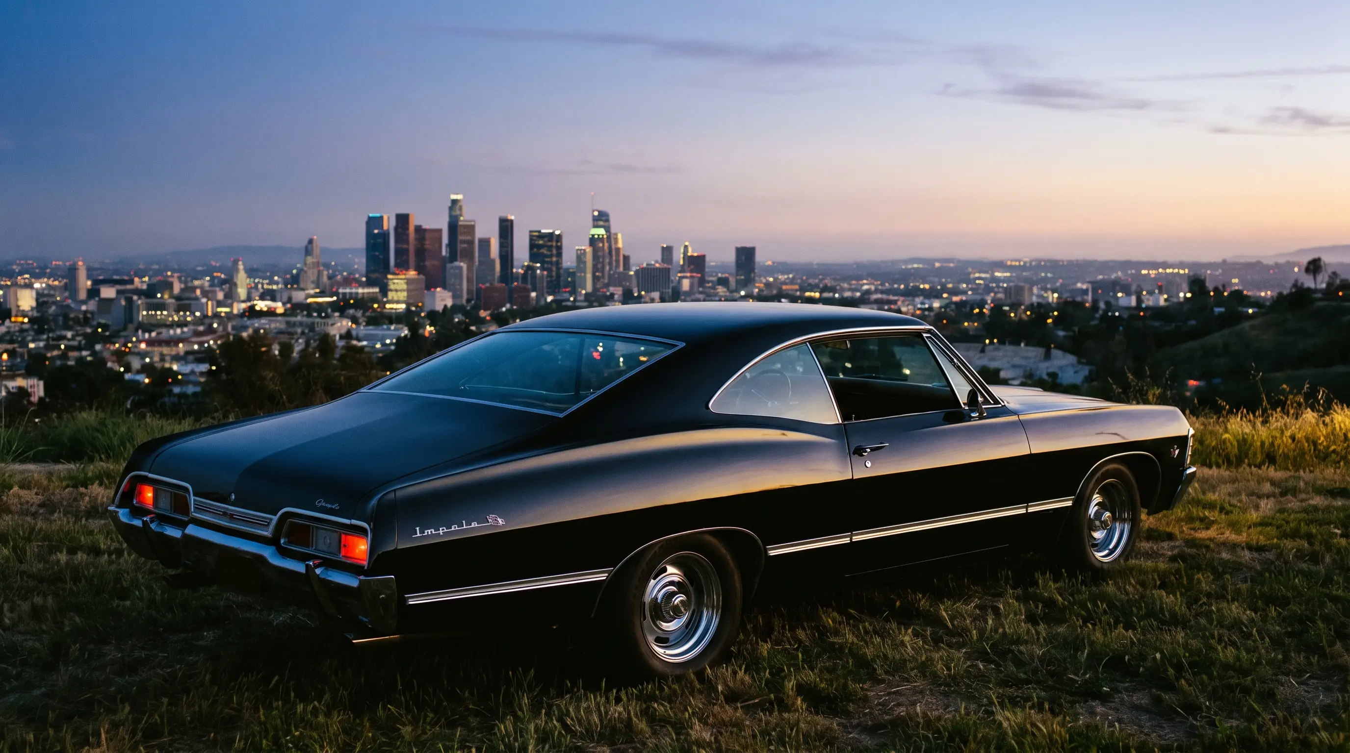Black 1967 Chevrolet Impala fastback on a hillside above a city skyline