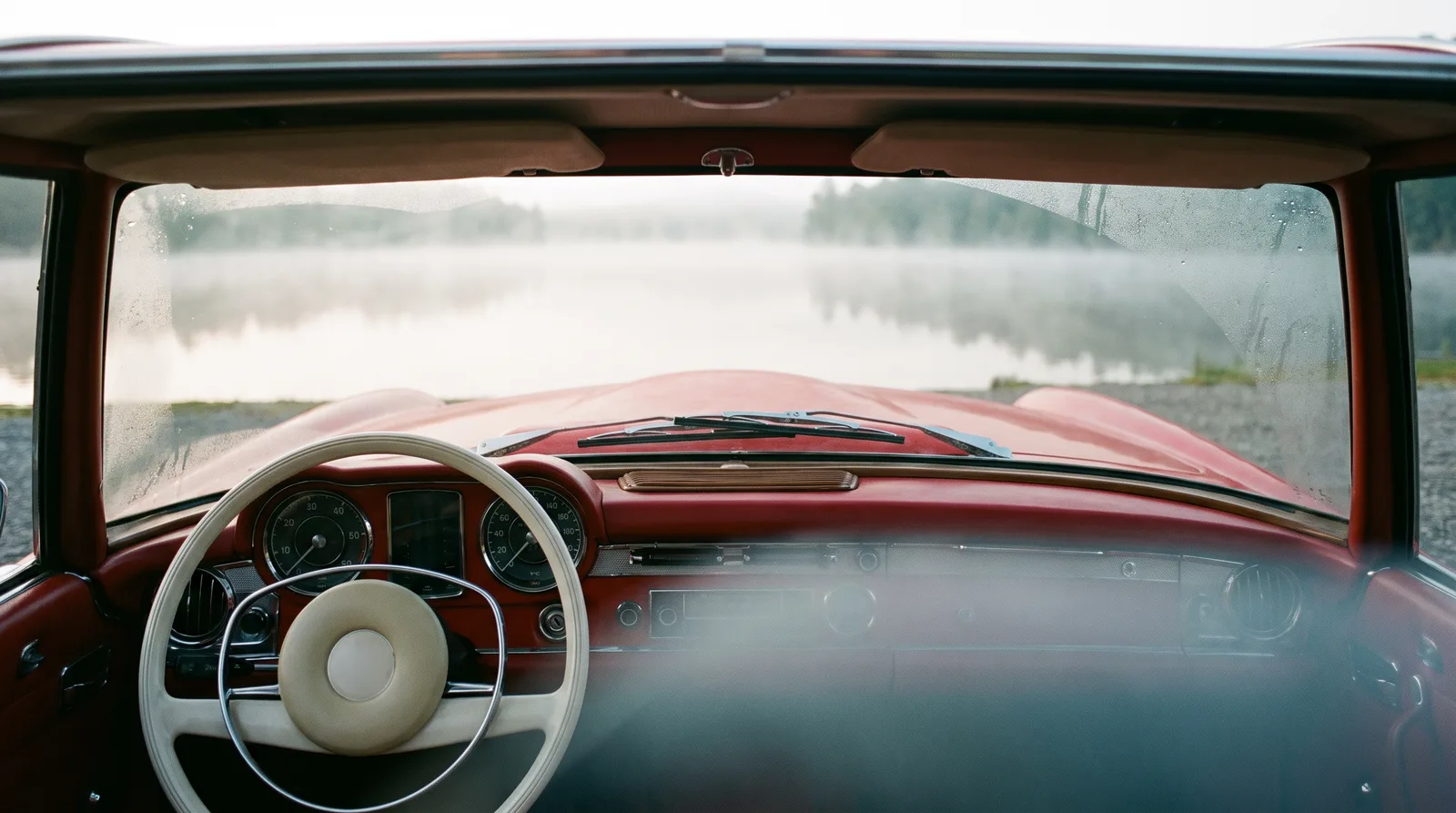 1965 Mercedes-Benz 230 SL â€” driver's view over a misty lake
