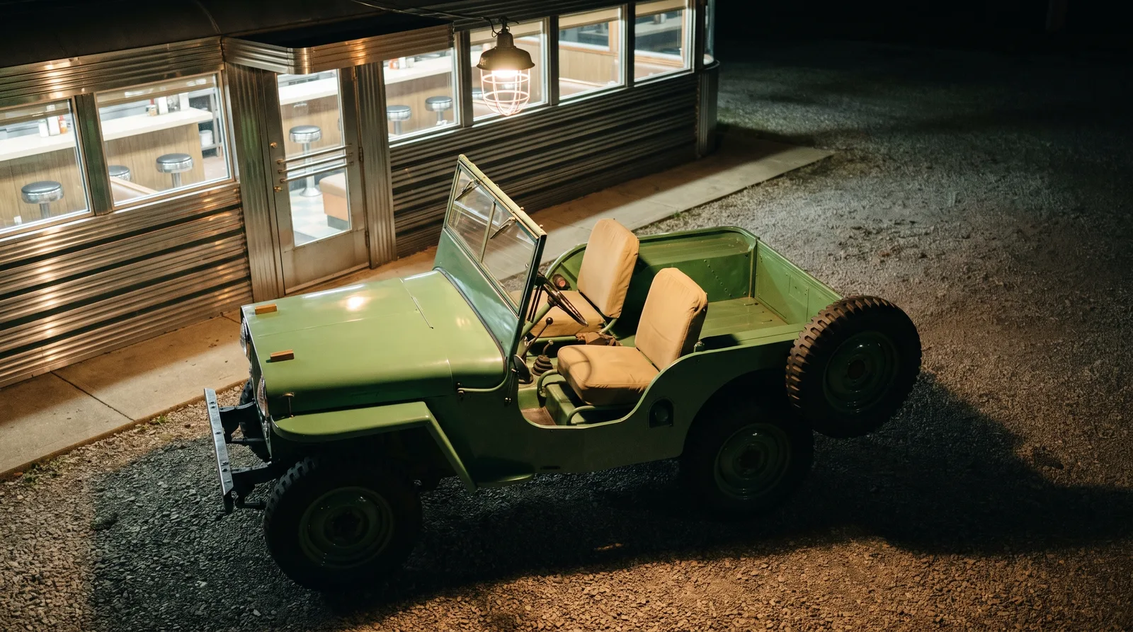 1946 Willys CJ-2A — parked beside a roadside diner at night