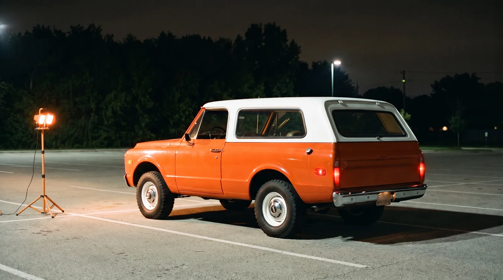 1969 Chevrolet K5 Blazer, orange and white in a lot at night