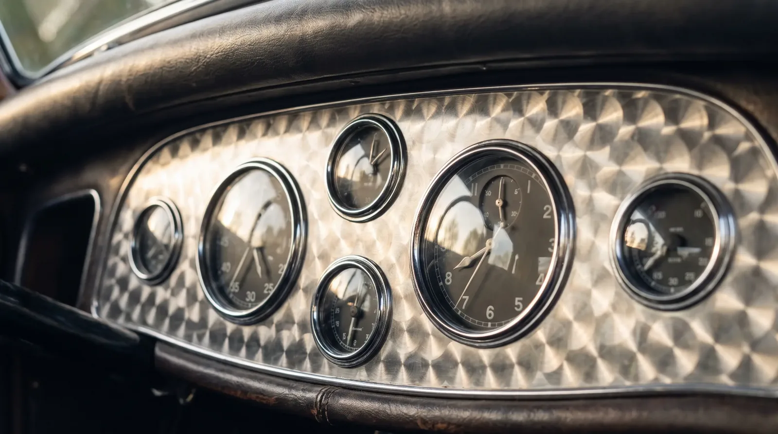 Engine-turned jeweled metal dashboard with round chrome gauges