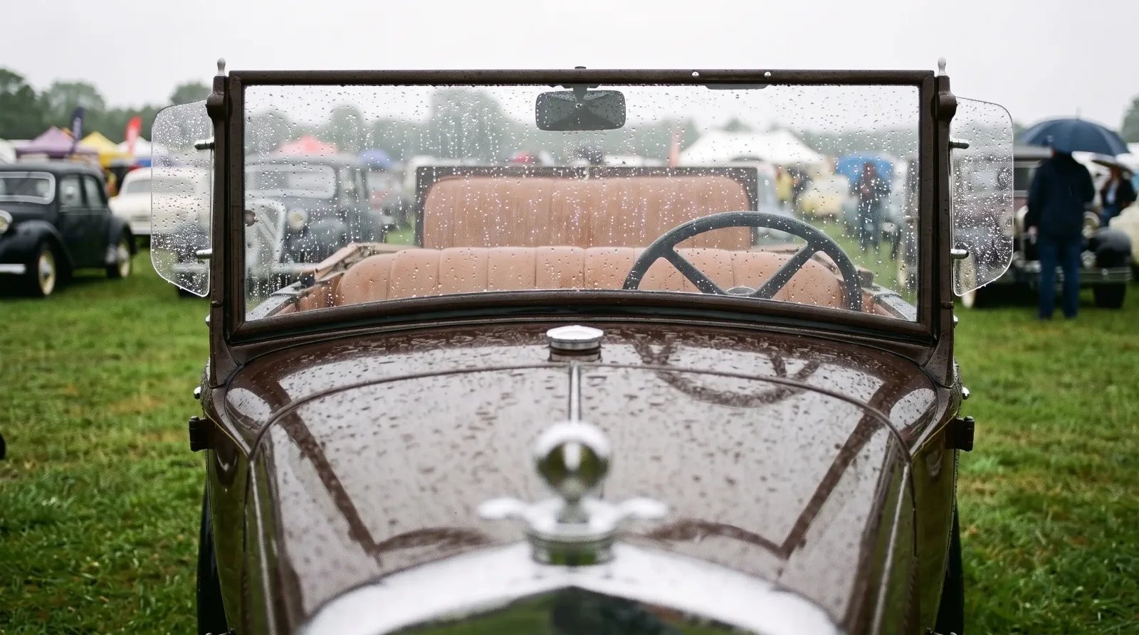 1930 Ford Model A open car seen through a rain-wet windshield on a show field