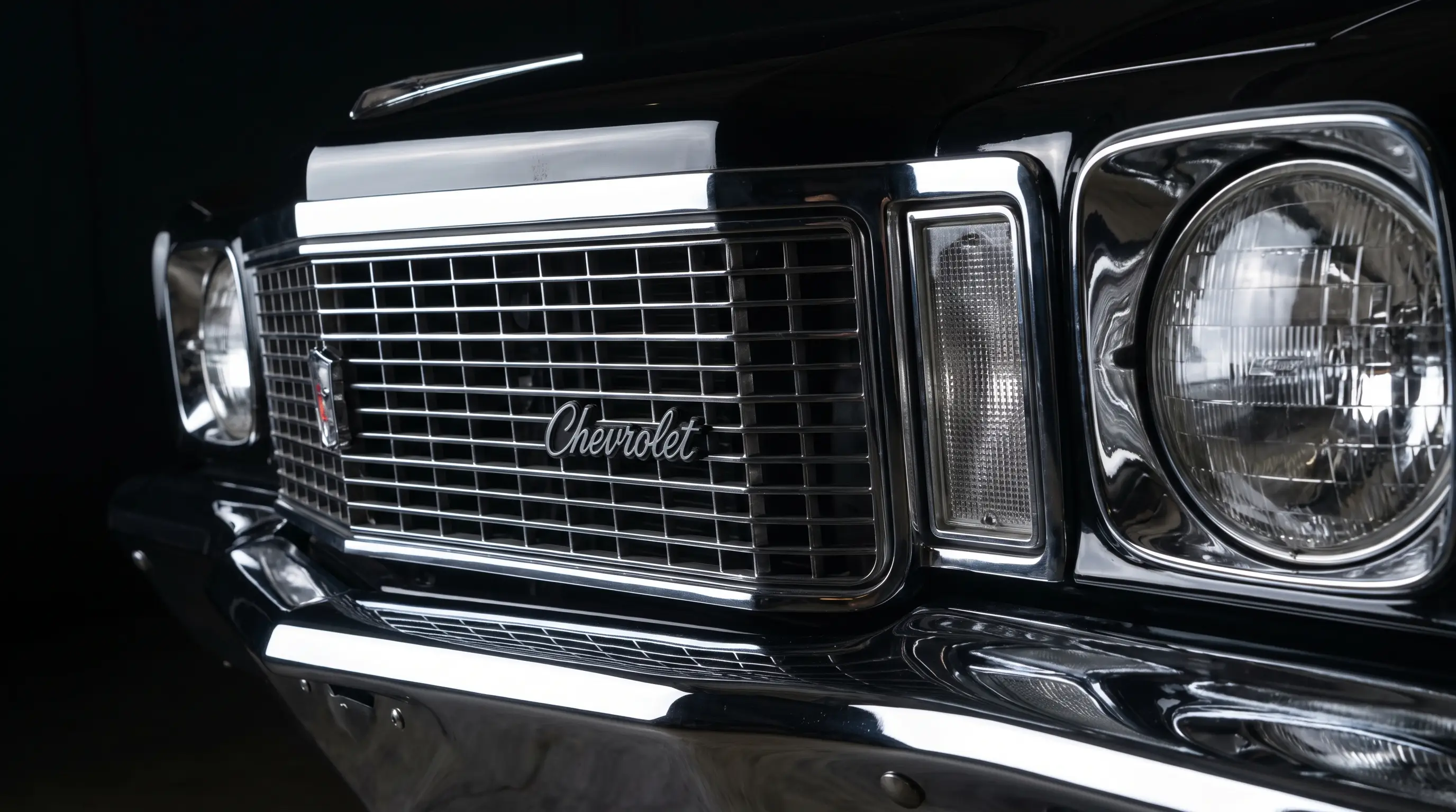 Close-up chrome grille and headlights of a 1971 Chevrolet Monte Carlo under studio lighting