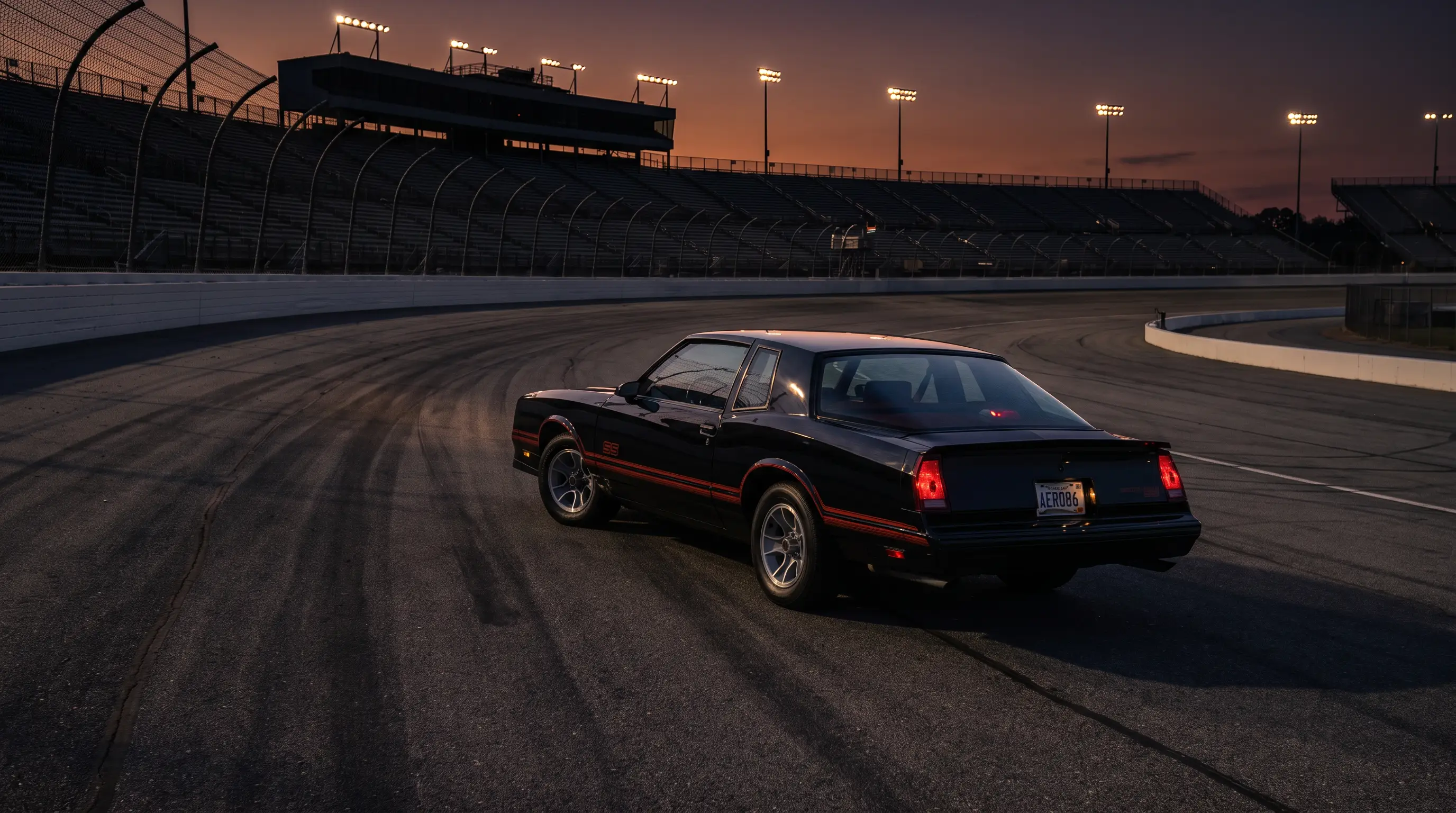Black 1986 Chevrolet Monte Carlo SS Aerocoupe on an empty speedway track at dusk