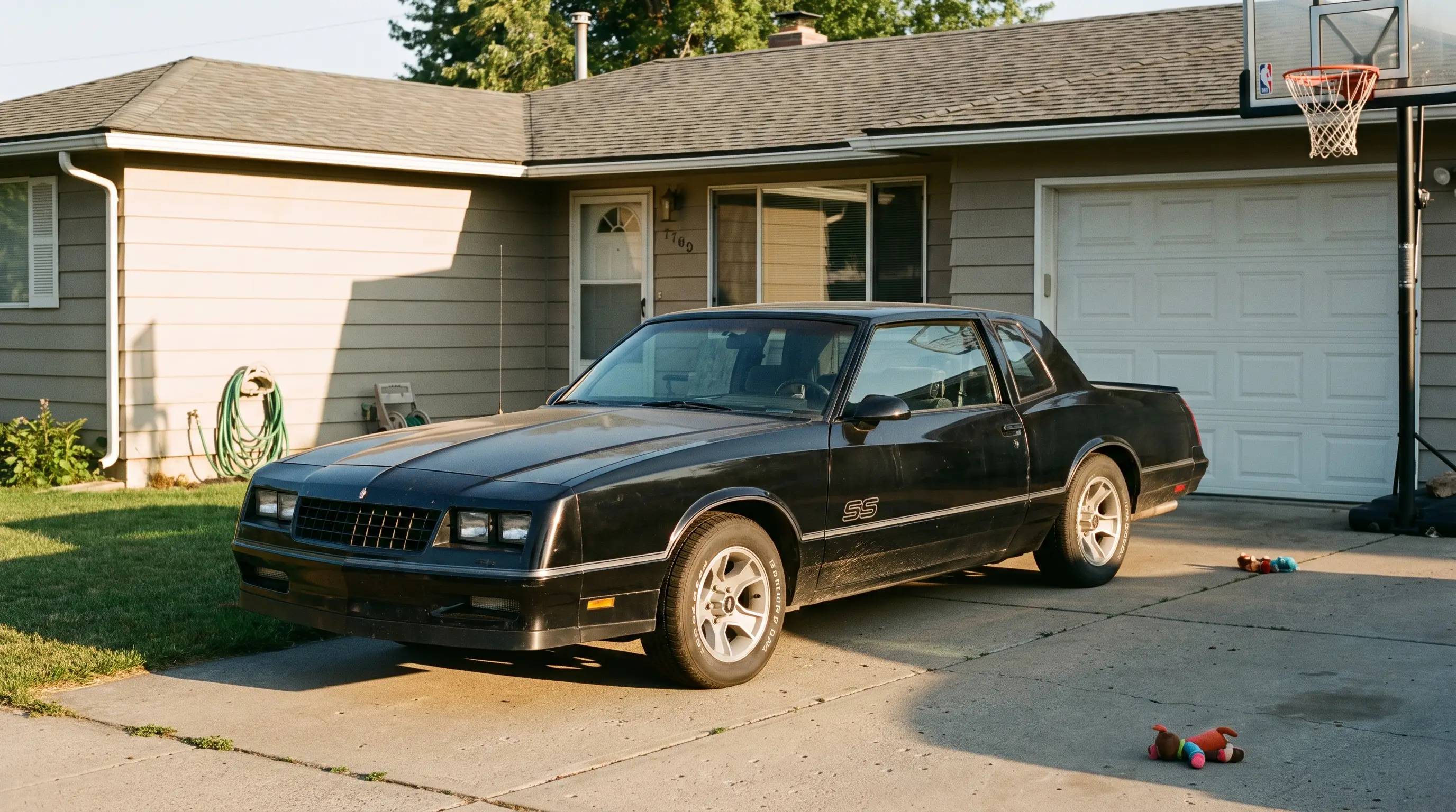 Black 1986 Monte Carlo SS parked in a suburban driveway in afternoon light