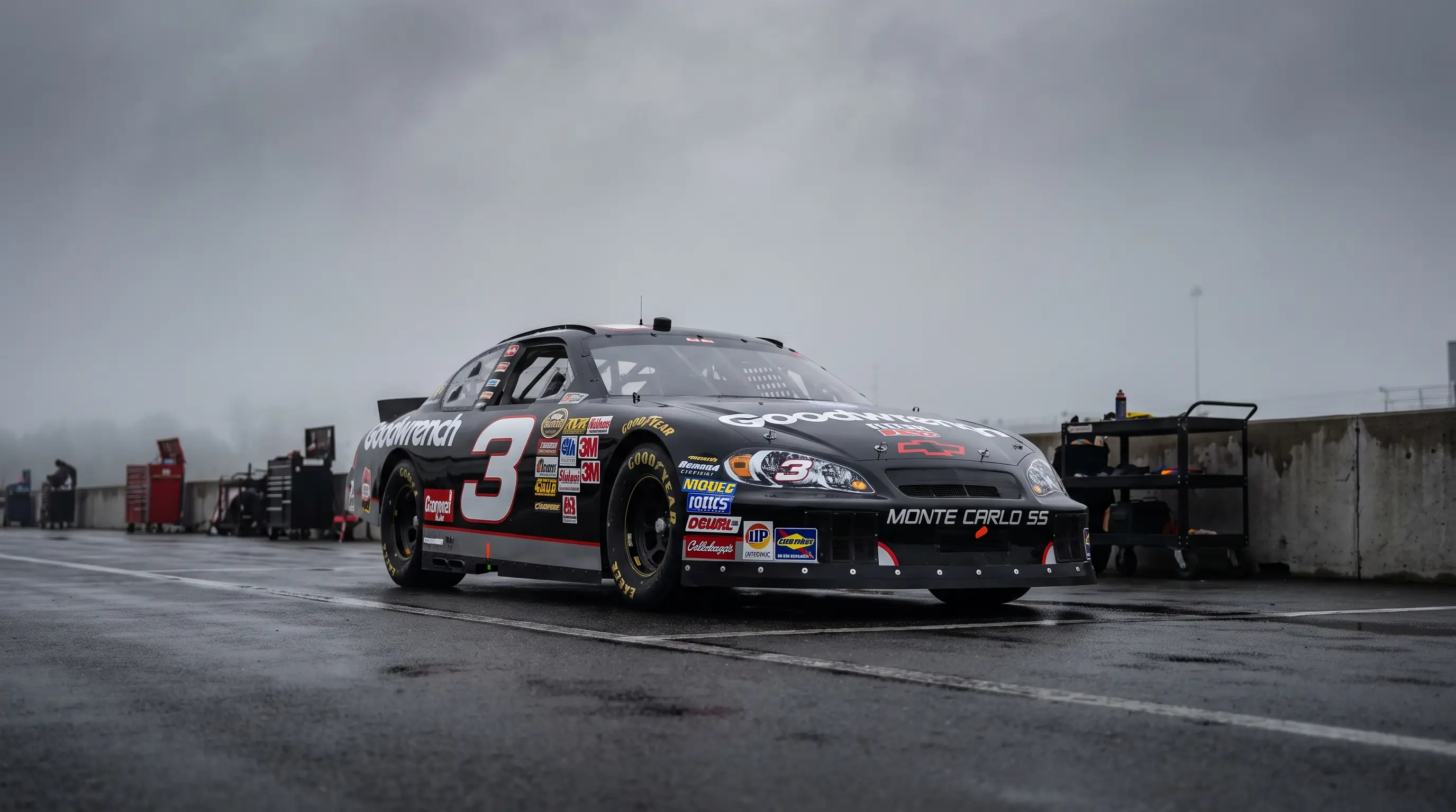 Black number 3 Monte Carlo SS NASCAR stock car parked on pit road under overcast sky