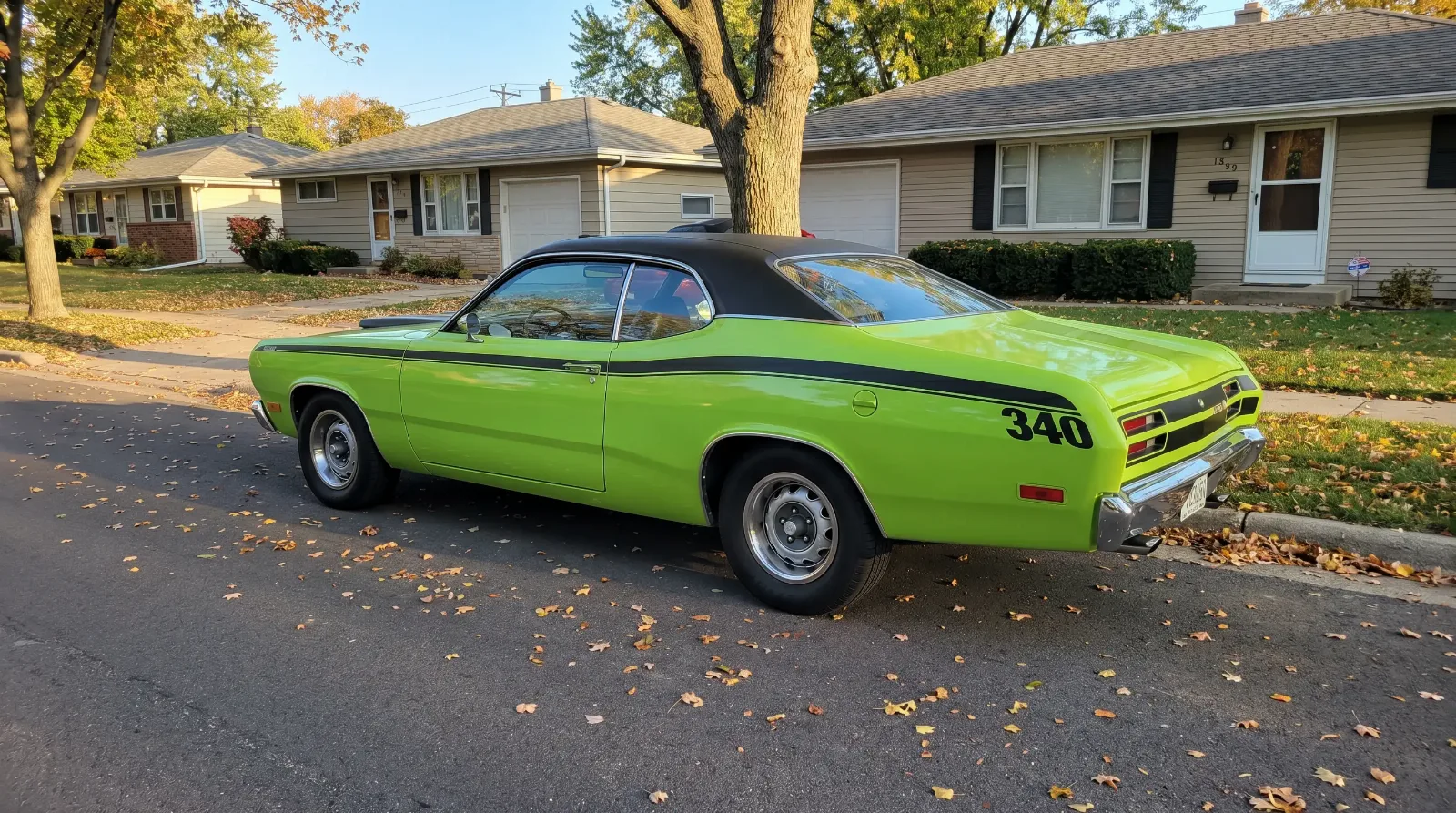 1970 Plymouth Duster 340 lime green parked on a suburban street