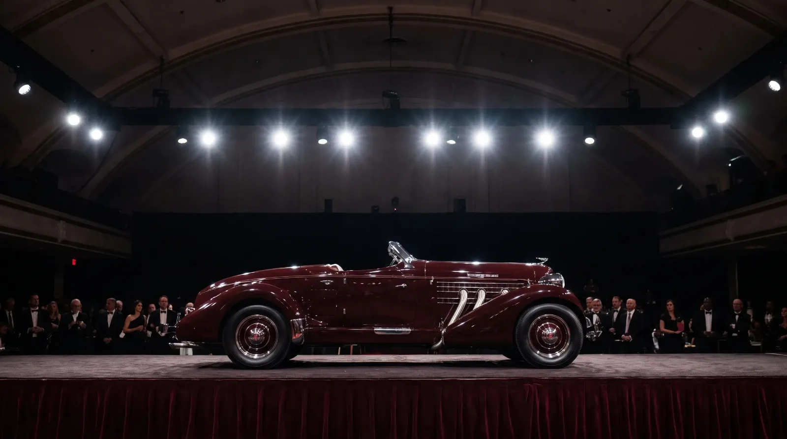 Pre-war roadster spotlighted on an auction stage