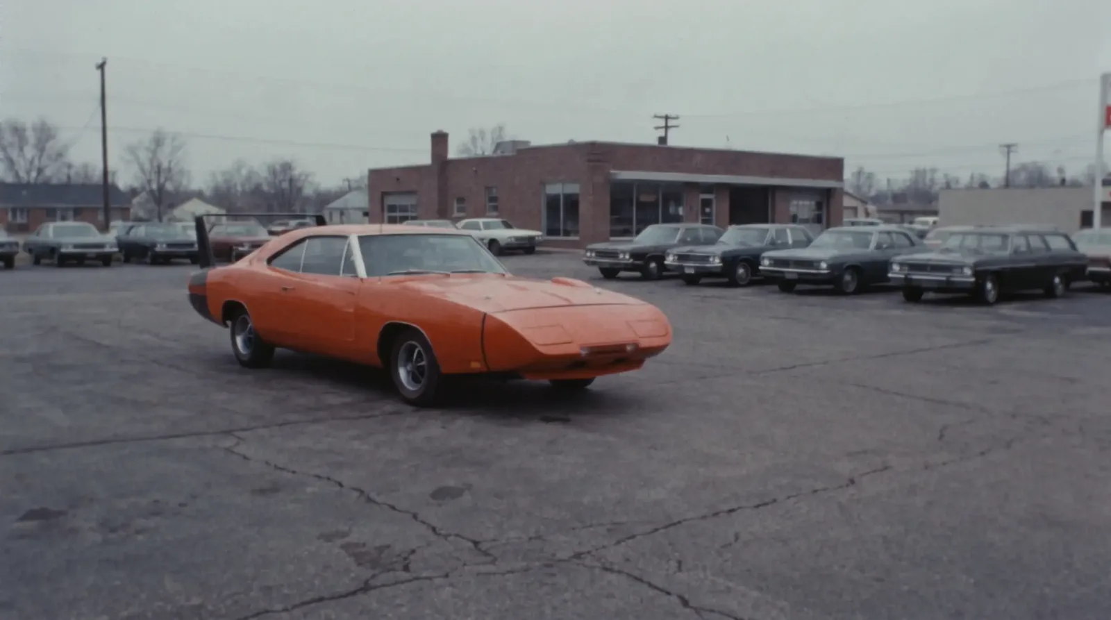 Winged Dodge Charger Daytona with nose cone parked alone on a 1969 dealership lot