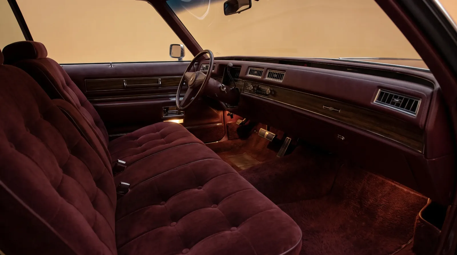 Tufted velour and woodgrain interior of a 1970s land yacht