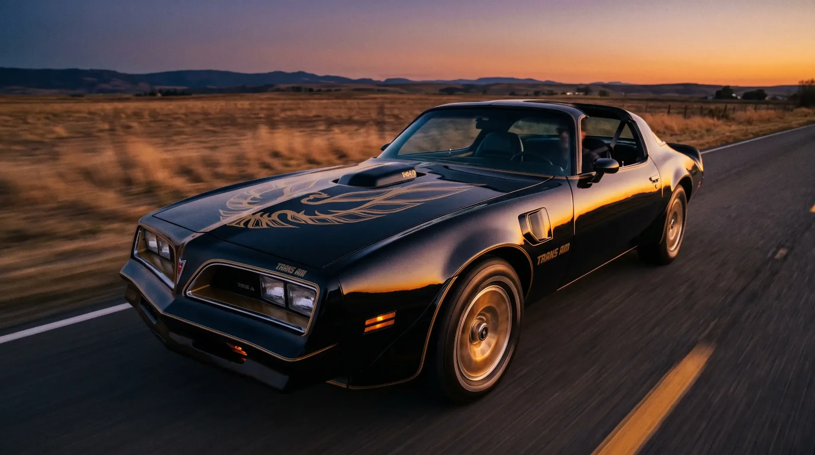 Black and gold 1977 Pontiac Trans Am Special Edition on a rural highway at dusk