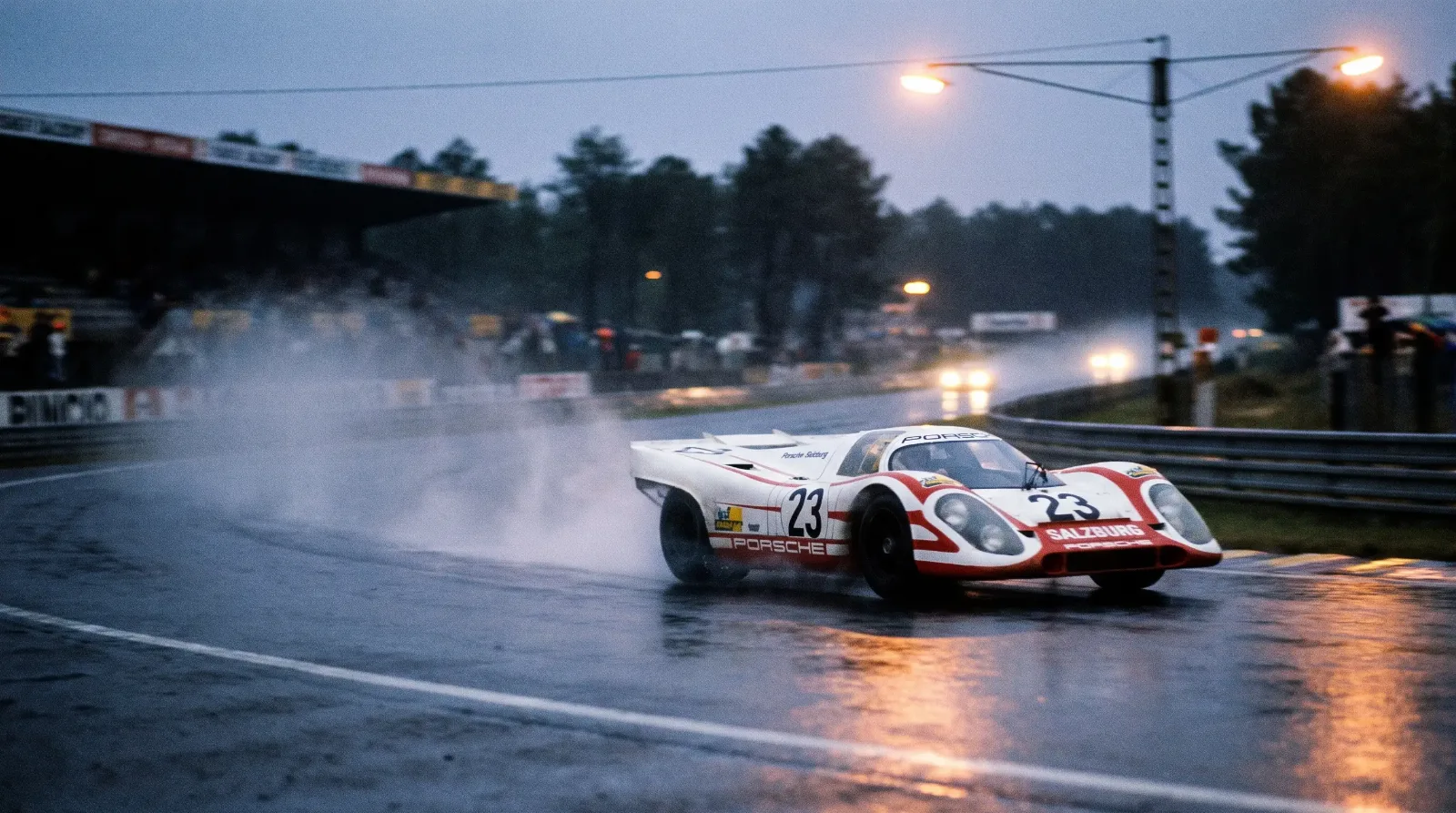 White and red Porsche 917K racing through a rain-soaked corner at Le Mans in 1970