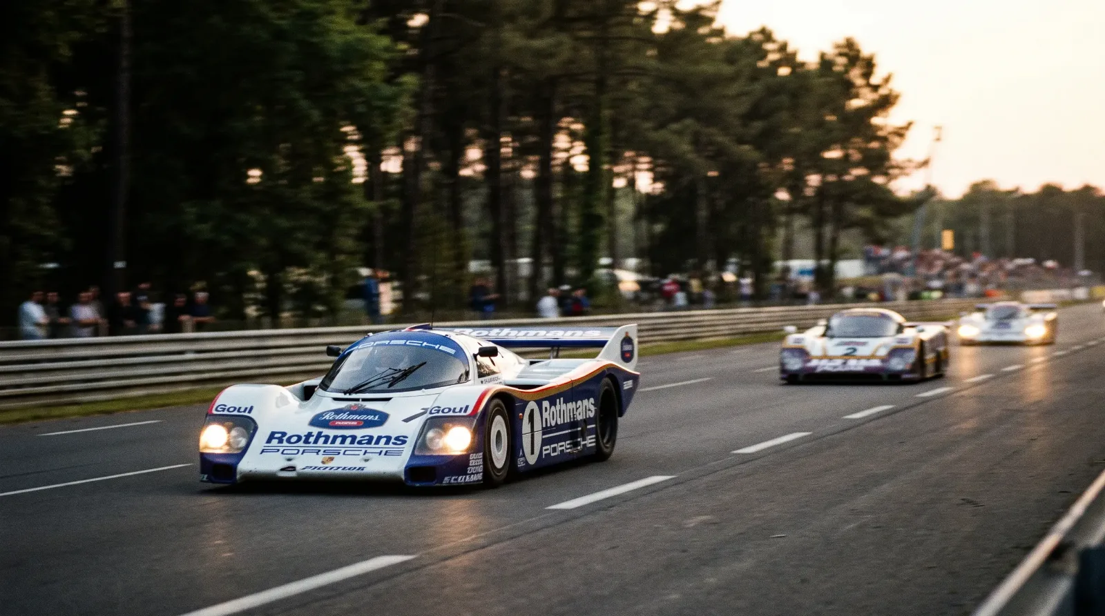 Rothmans Porsche 962 Group C prototype racing down the Mulsanne straight at Le Mans