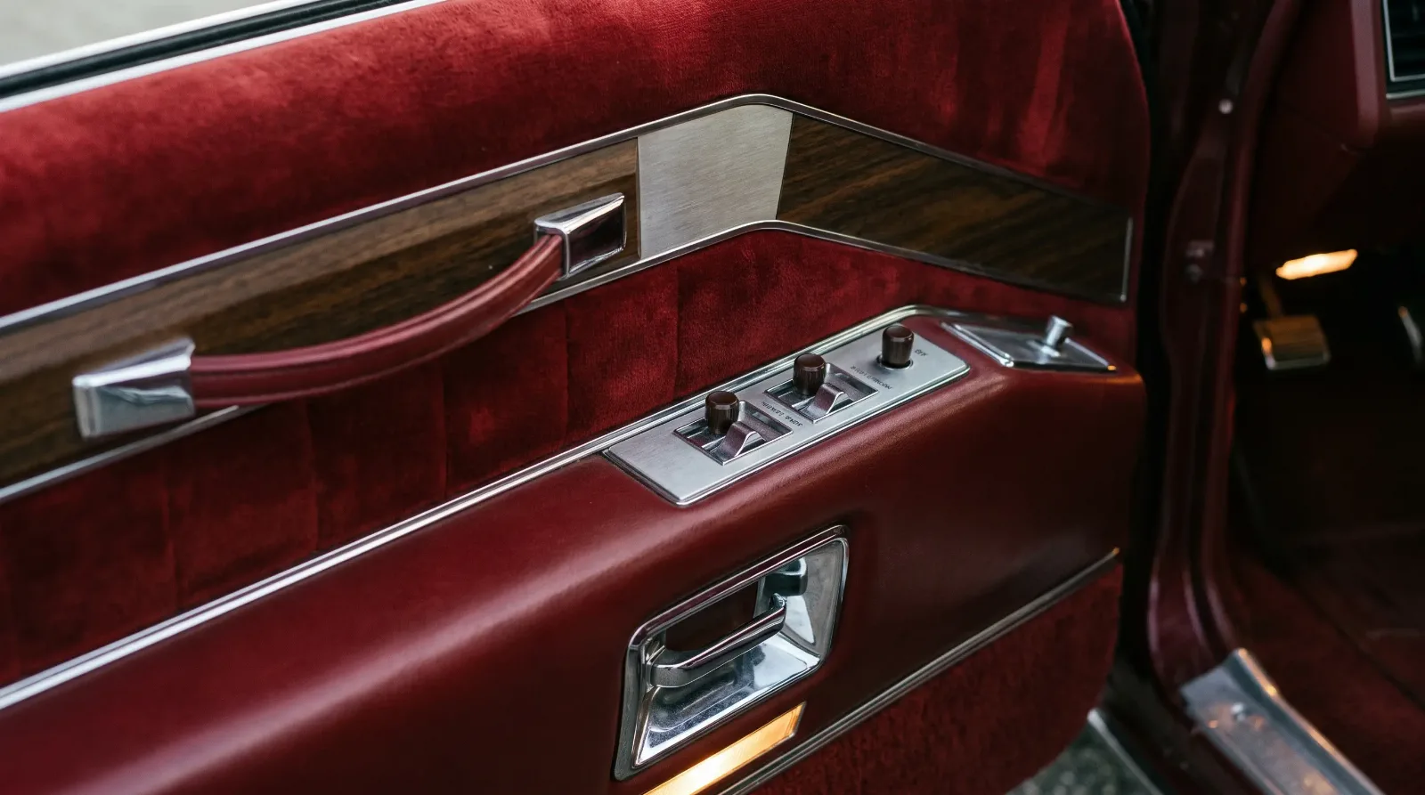 Vintage luxury car door panel with chrome power switches